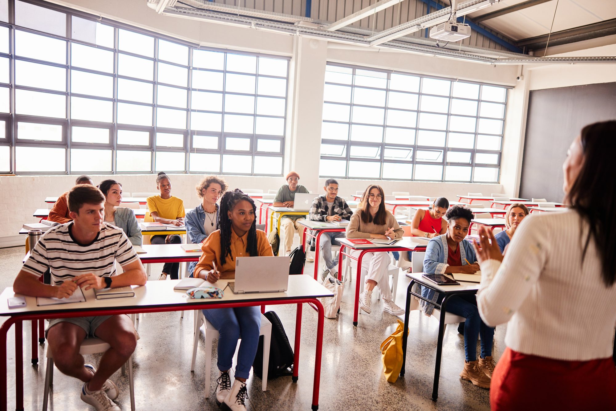 Teacher talking with smiling students during a classroom lesson