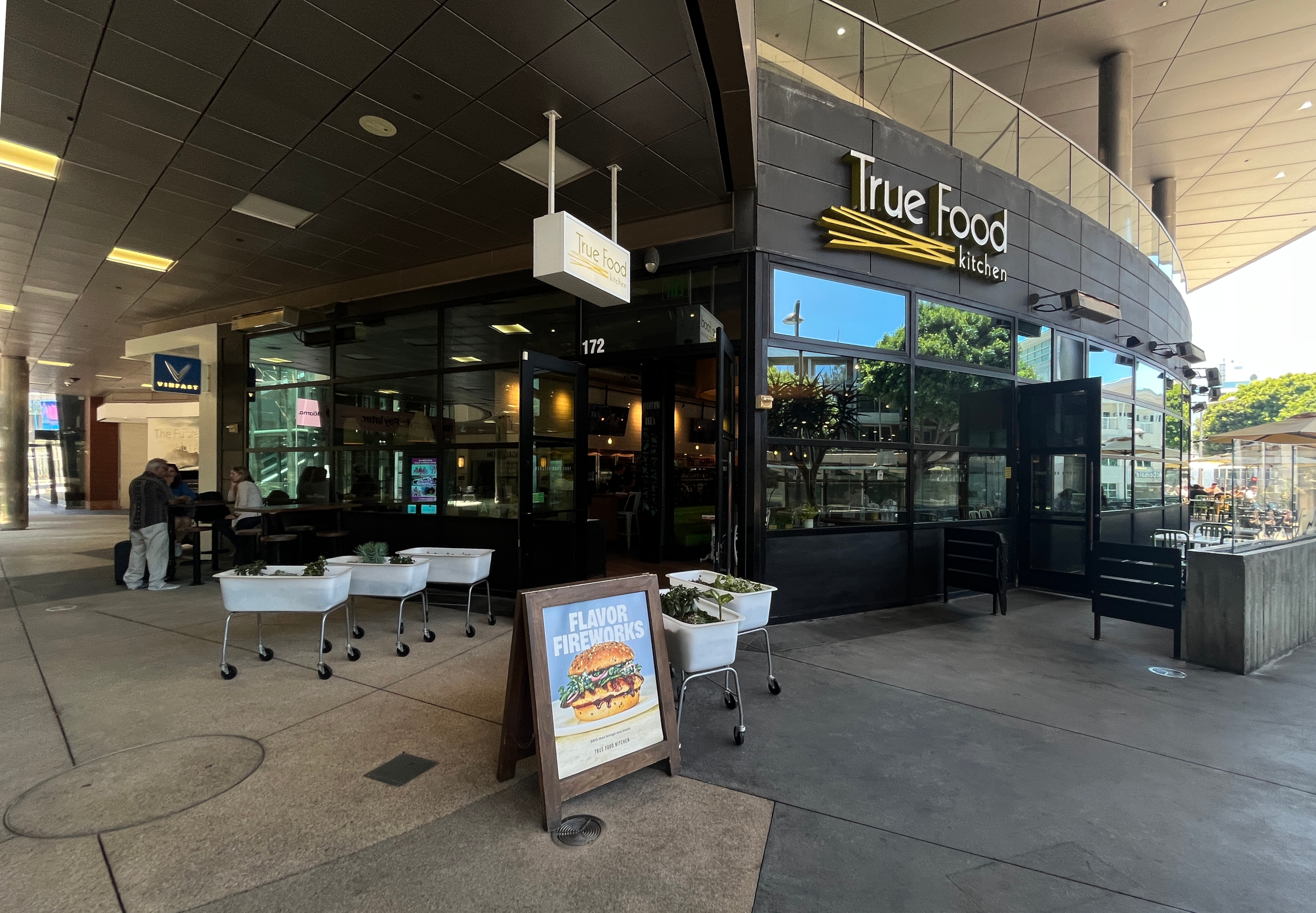 Exterior of a True Food Kitchen restaurant with outdoor seating and brand signage.