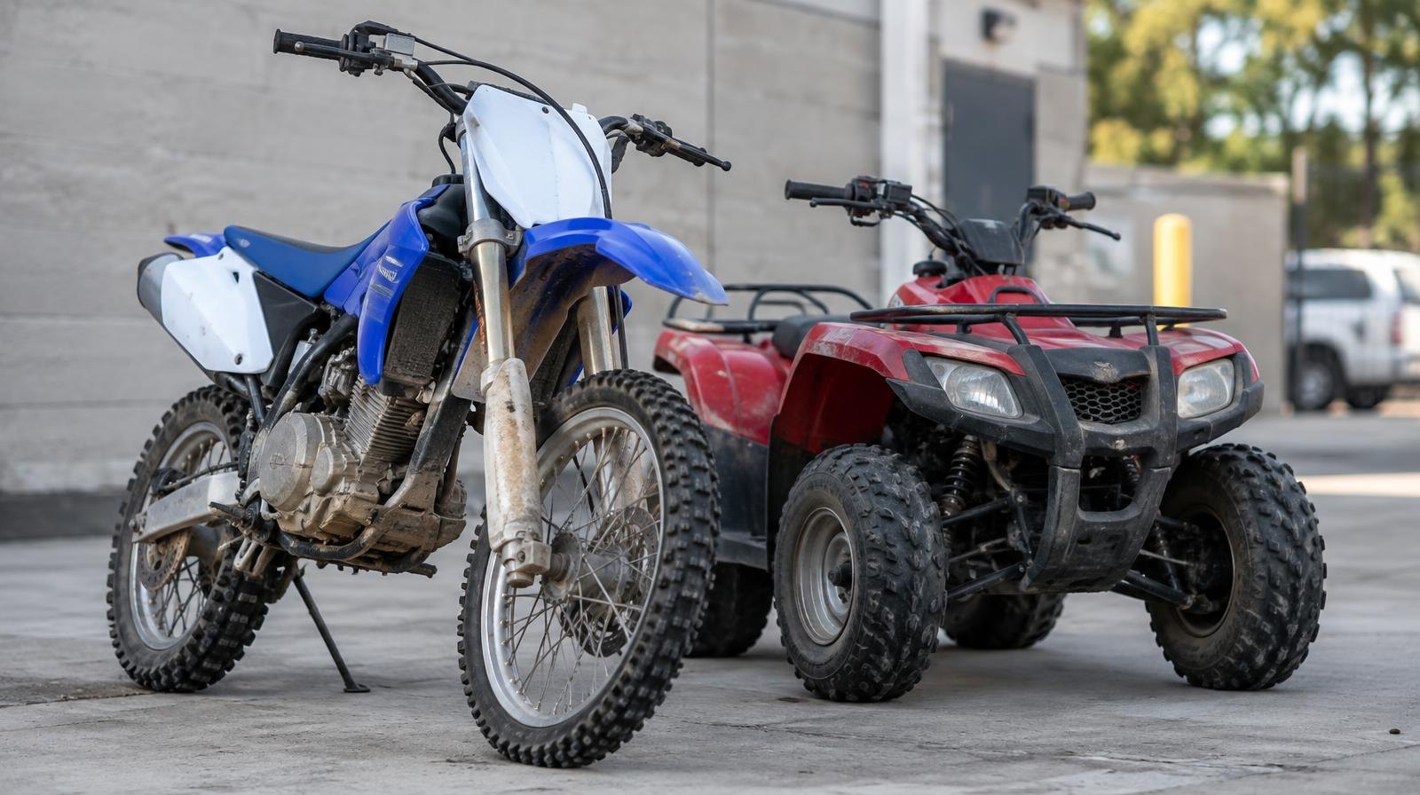 A dirt bike and a small ATV parked side by side on a concrete surface.