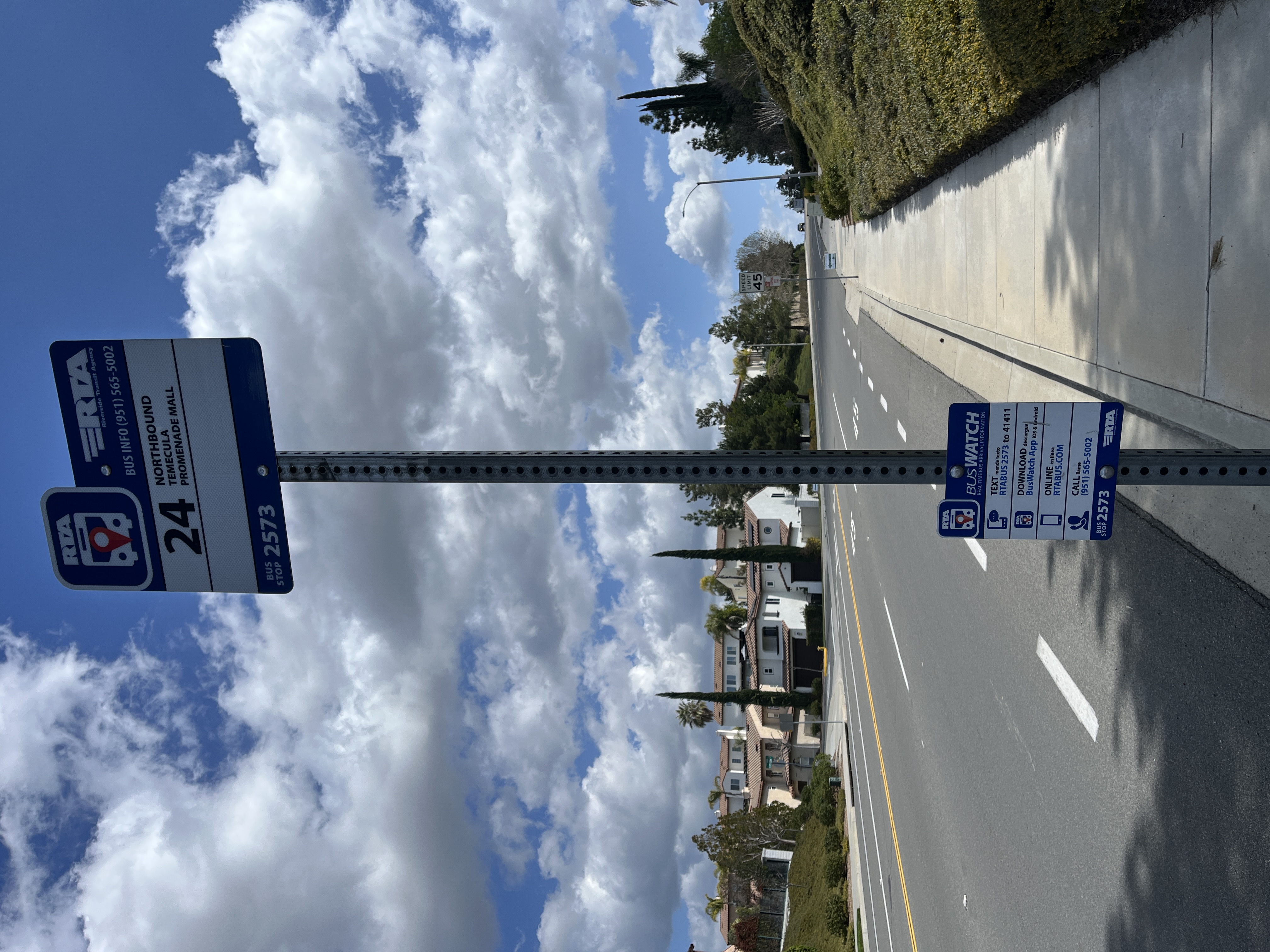 A Riverside Transit Agency bus stop sign pole on a suburban sidewalk with no bench or shelter.