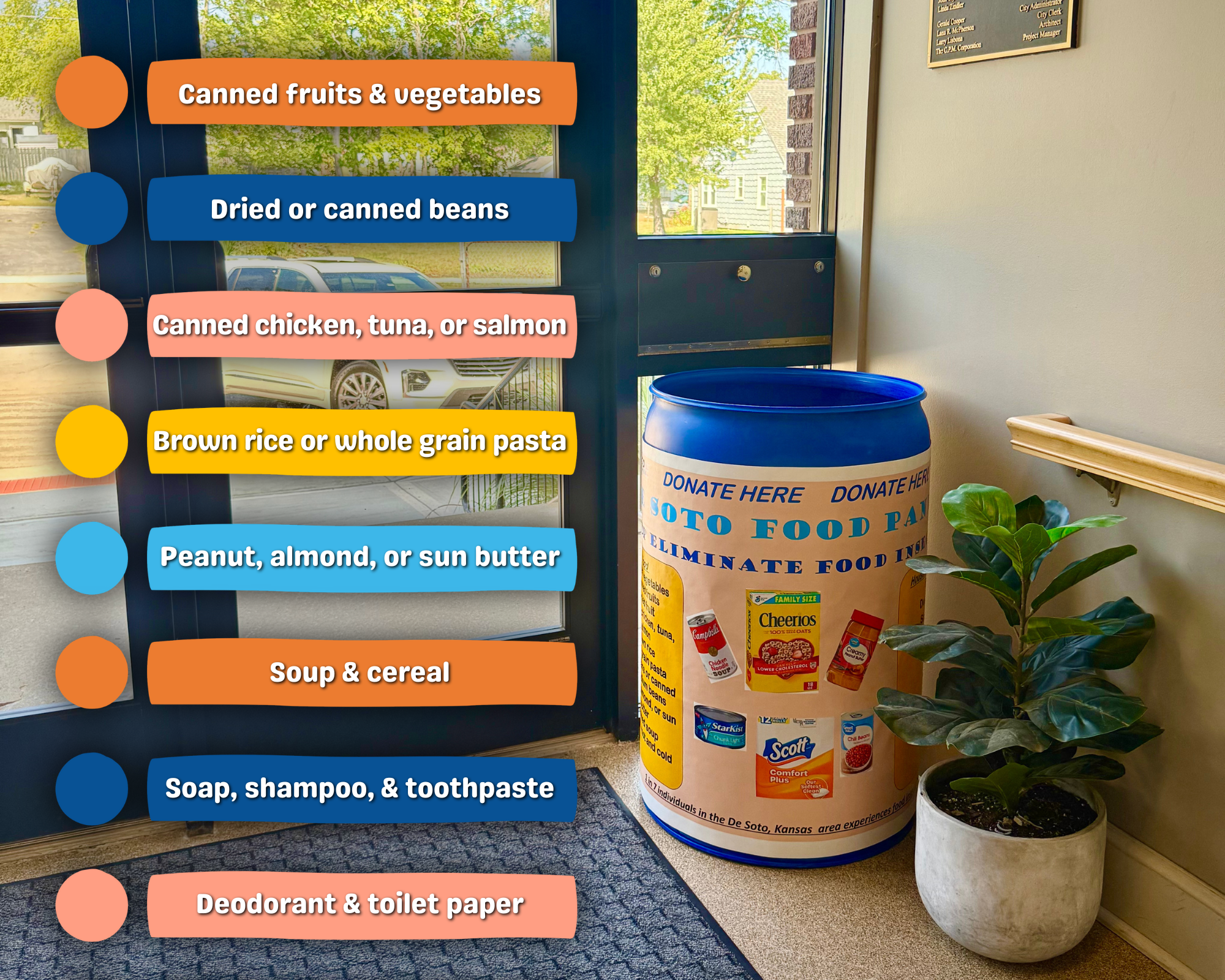 A large cylindrical donation barrel labeled 'Donate Here' in a building lobby.