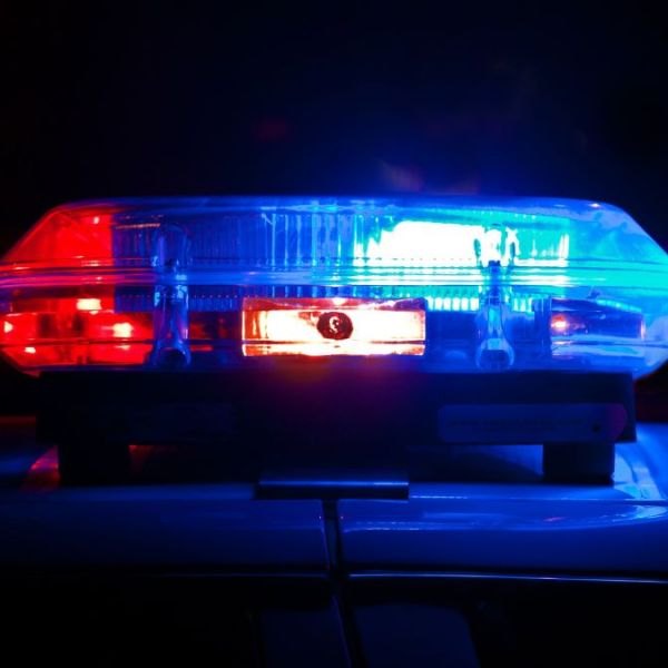Red and blue police emergency lights illuminated on a patrol vehicle at night.
