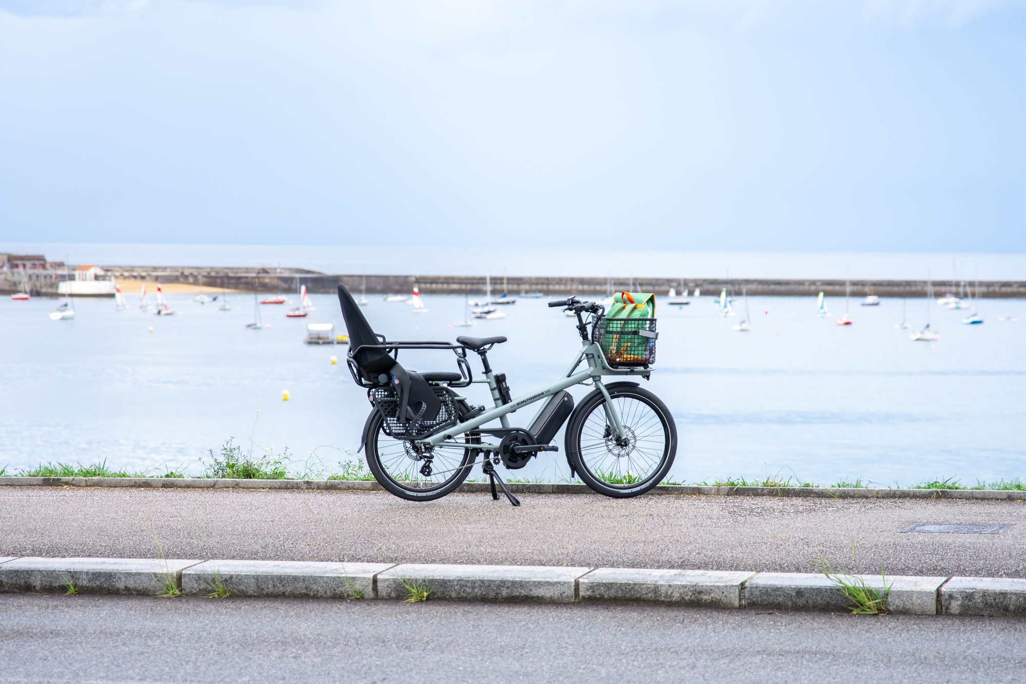 Electric cargo bike on a scenic oceanfront path in France, ideal for coastal rides.