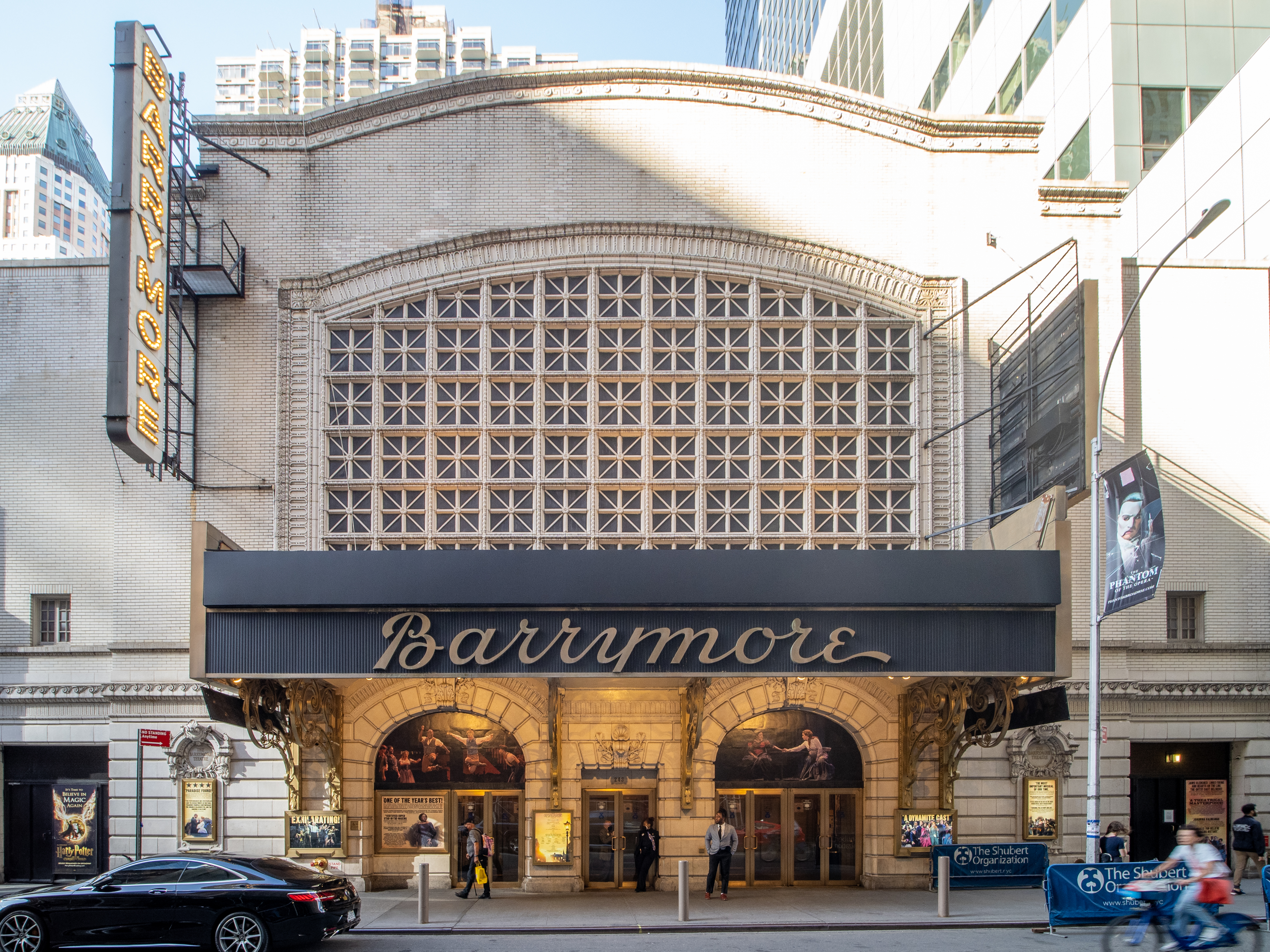 Ornate theater facade with arched lattice design and vertical Barrymore sign on a city street.