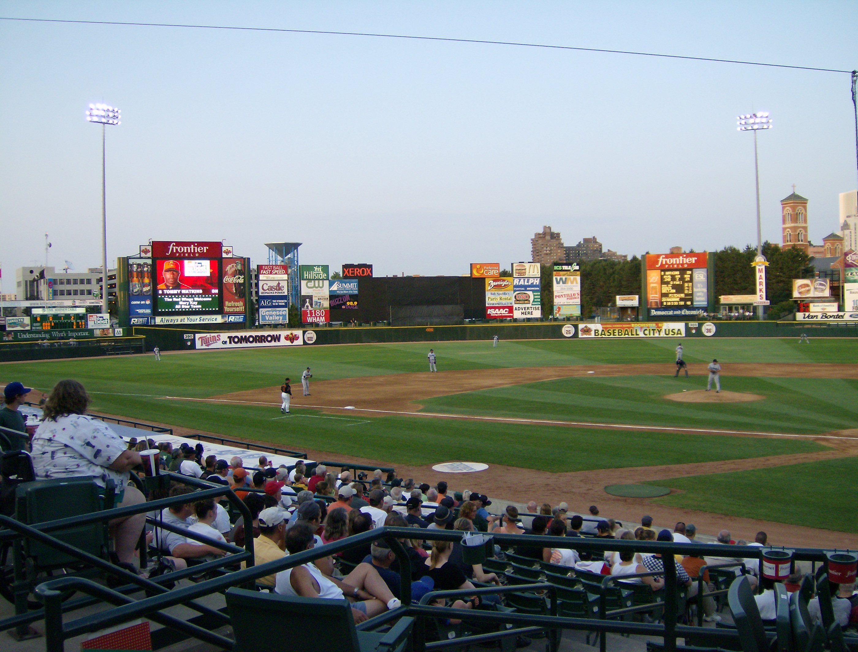 Baseball game in progress at Frontier Field with Rochester skyline beyond the outfield.