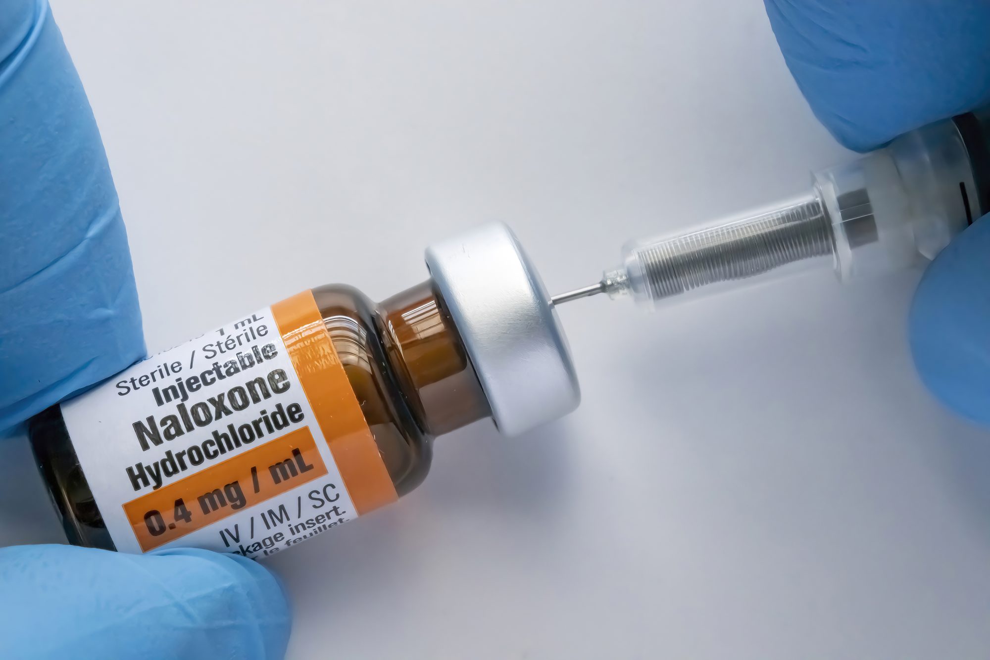 A person using a Naloxone vial with a syringe stock photo