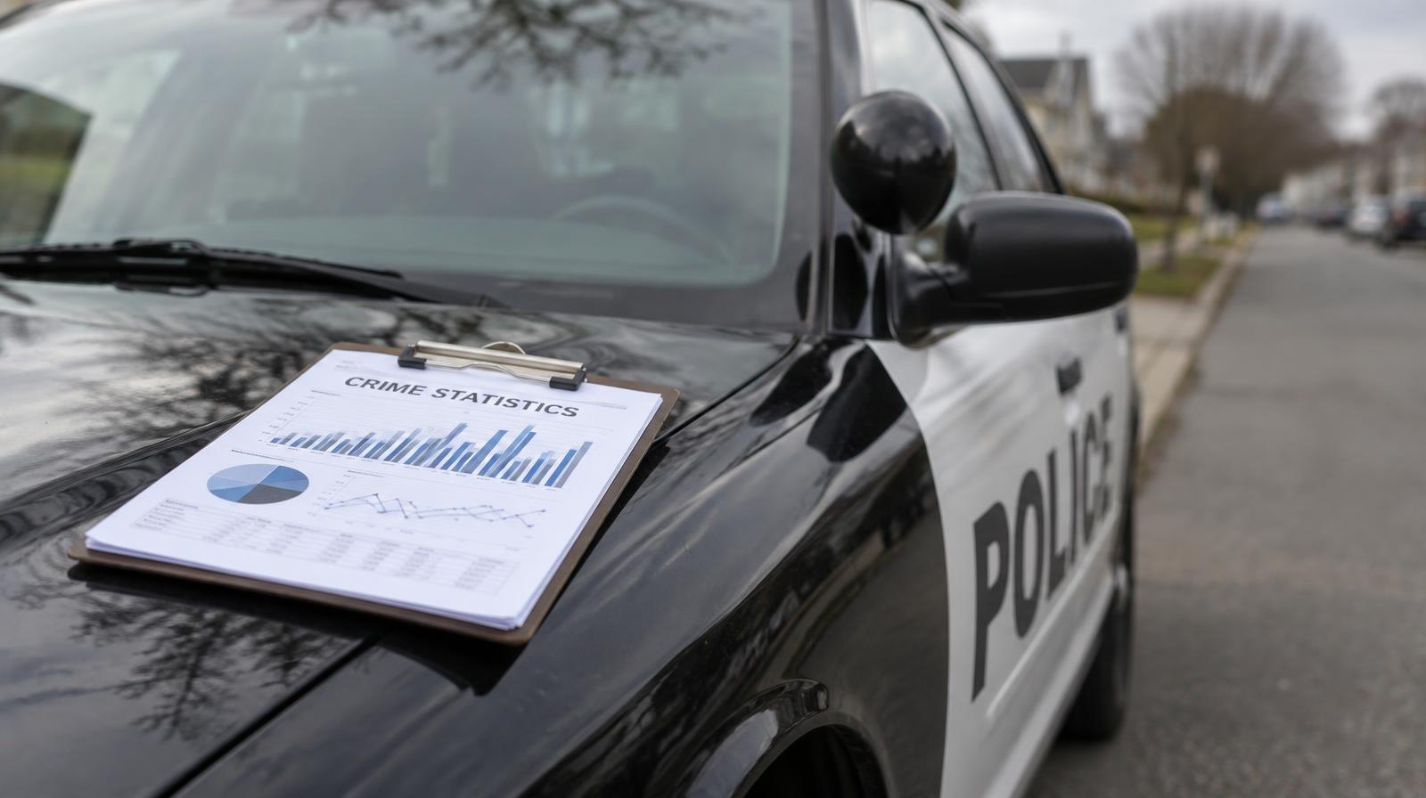 A marked police patrol car parked along a quiet suburban street.