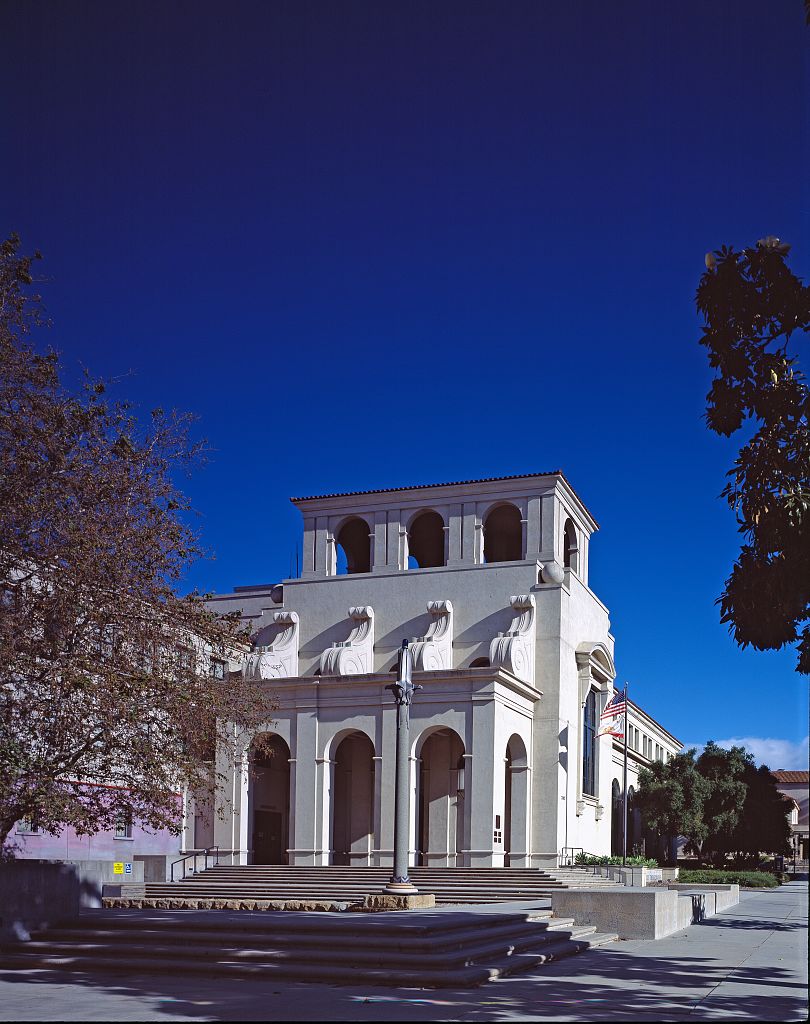 Neoclassical police department building with arched windows and a bell tower.