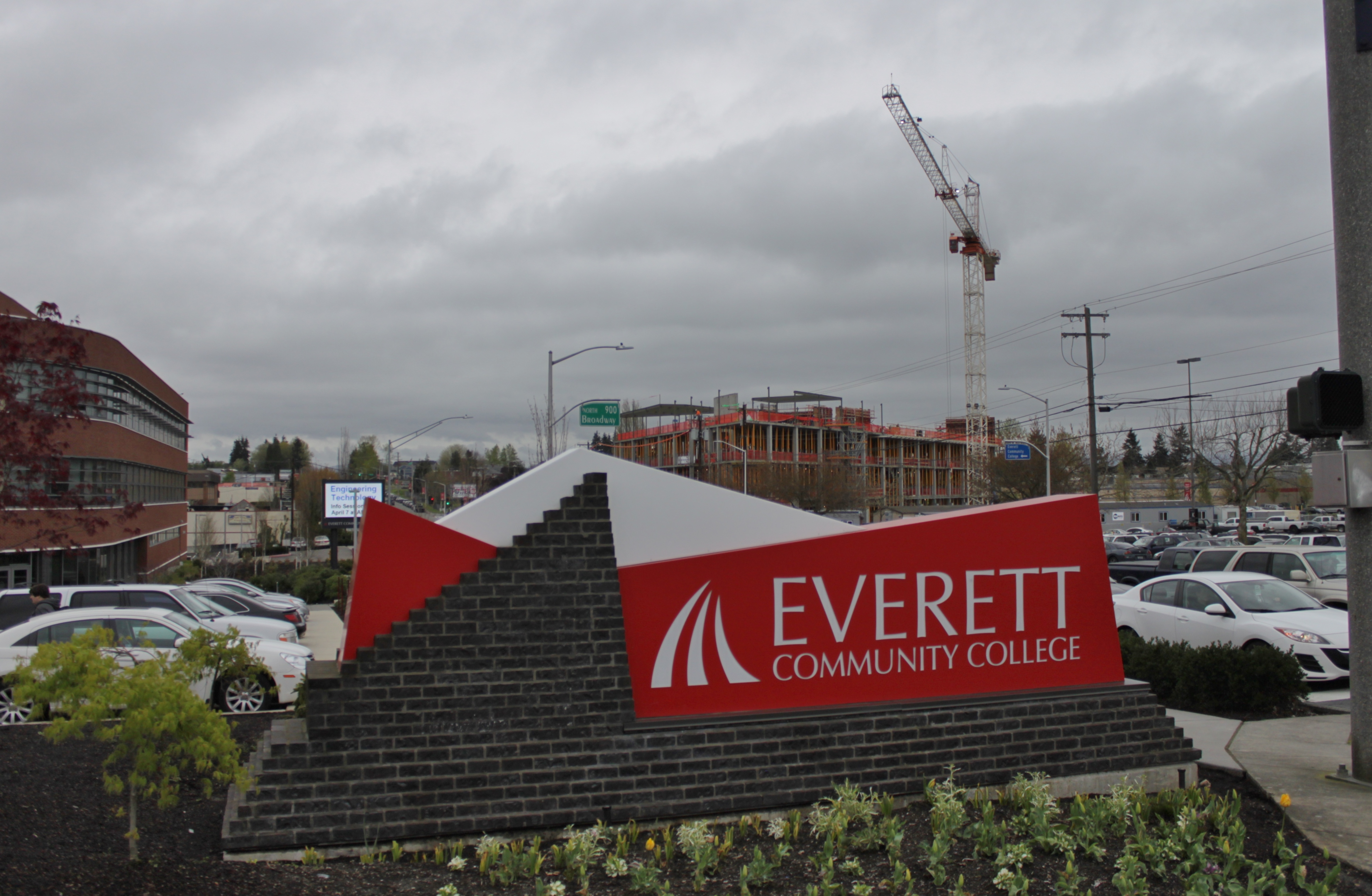 Everett Community College entrance sign monument with a parking lot and construction crane behind it.
