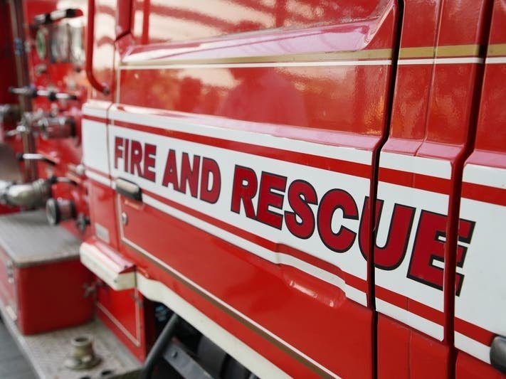 Close-up of a red fire and rescue truck showing lettering and equipment valves.