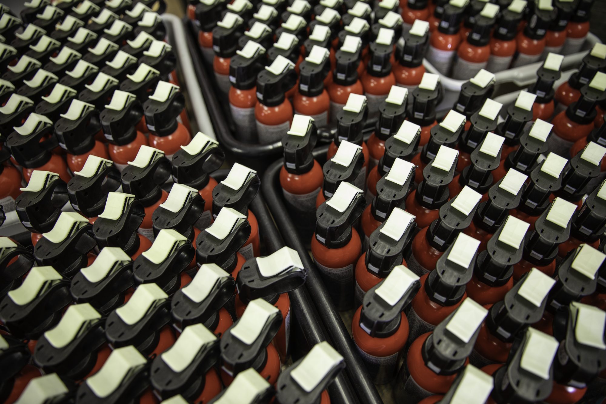 Bear spray canisters assembled and filled with ingredients in a factory. 