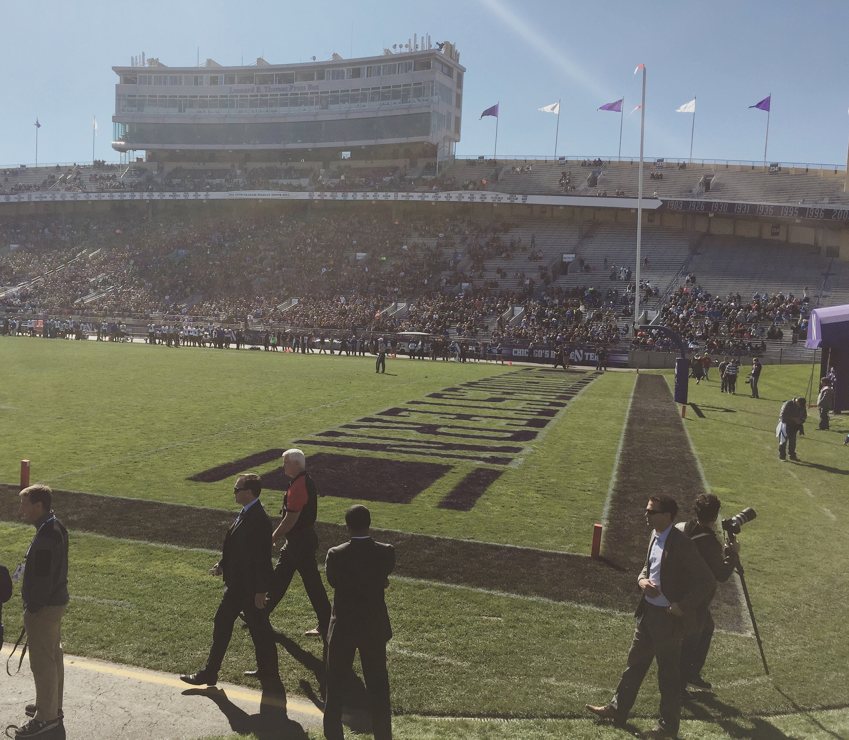Football stadium endzone with Northwestern painted on the turf and spectators in the grandstand.