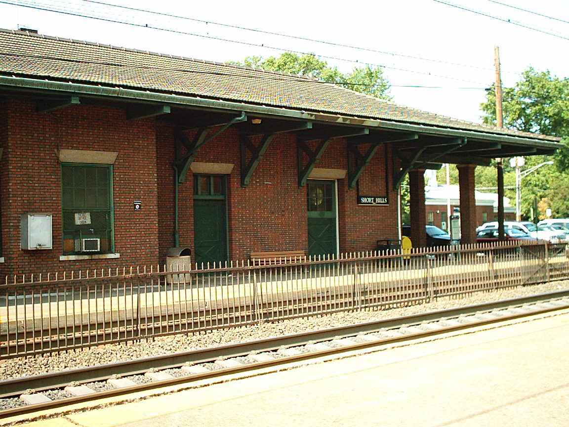 Red brick train station building with covered platform and Short Hills sign.