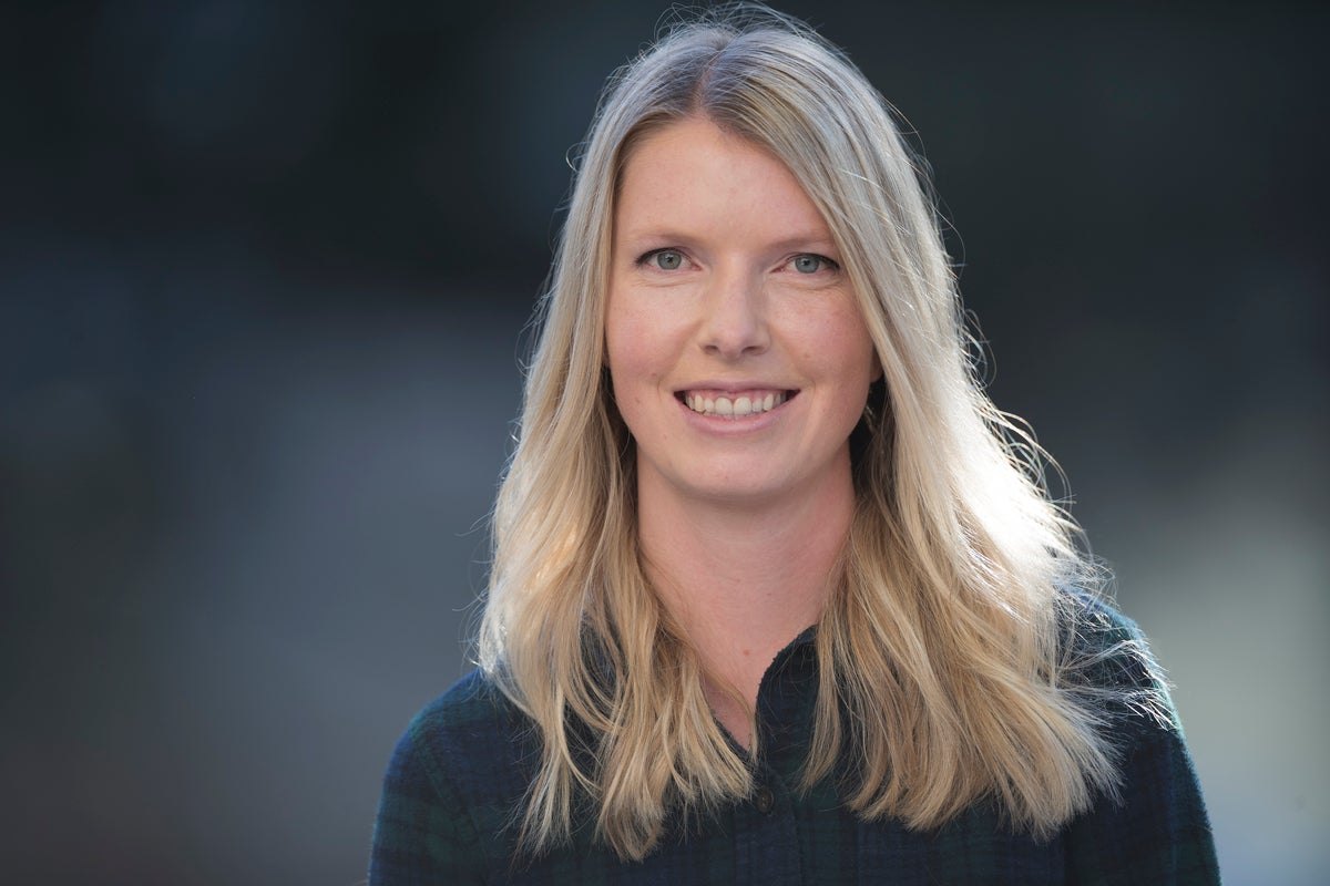 Woman with long blonde hair in a professional outdoor portrait.