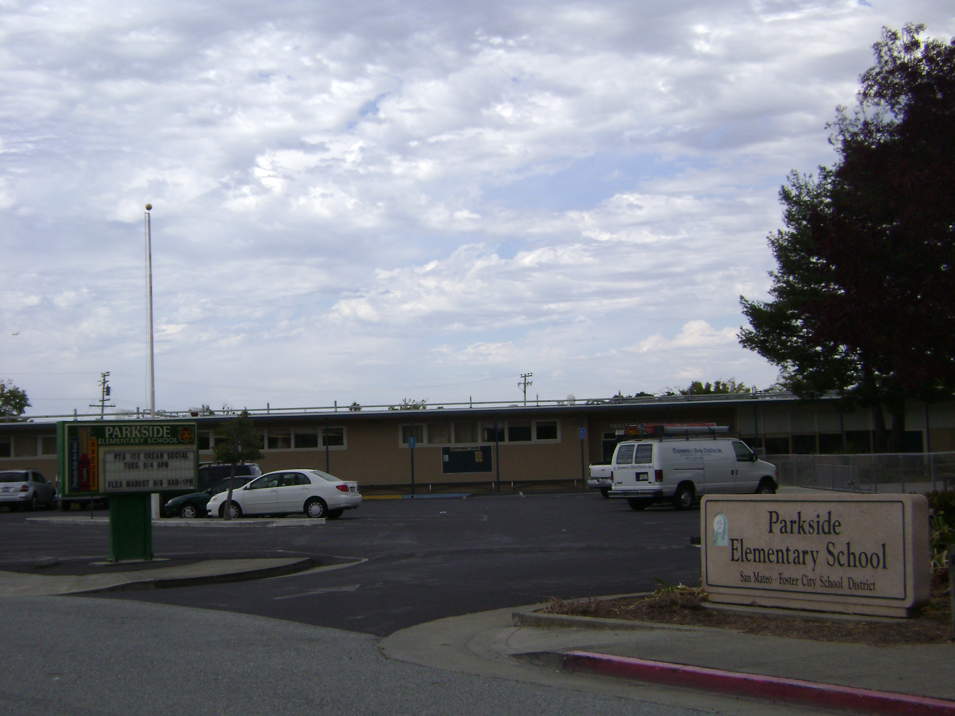 Exterior of an elementary school with a district sign and marquee in front.