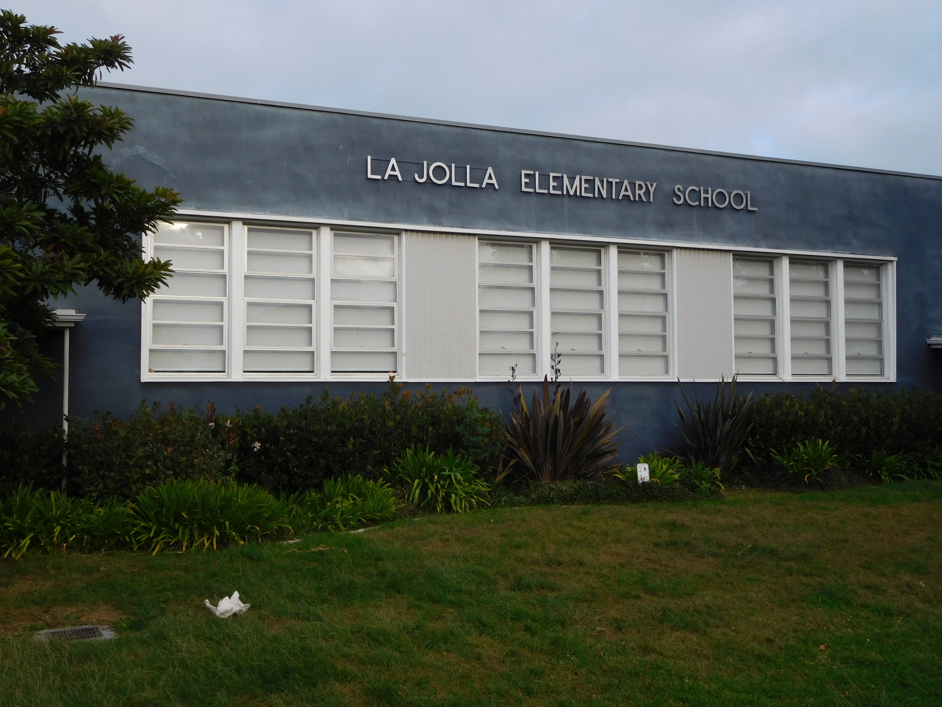 Exterior of La Jolla Elementary School with dark blue facade and white louvered windows.
