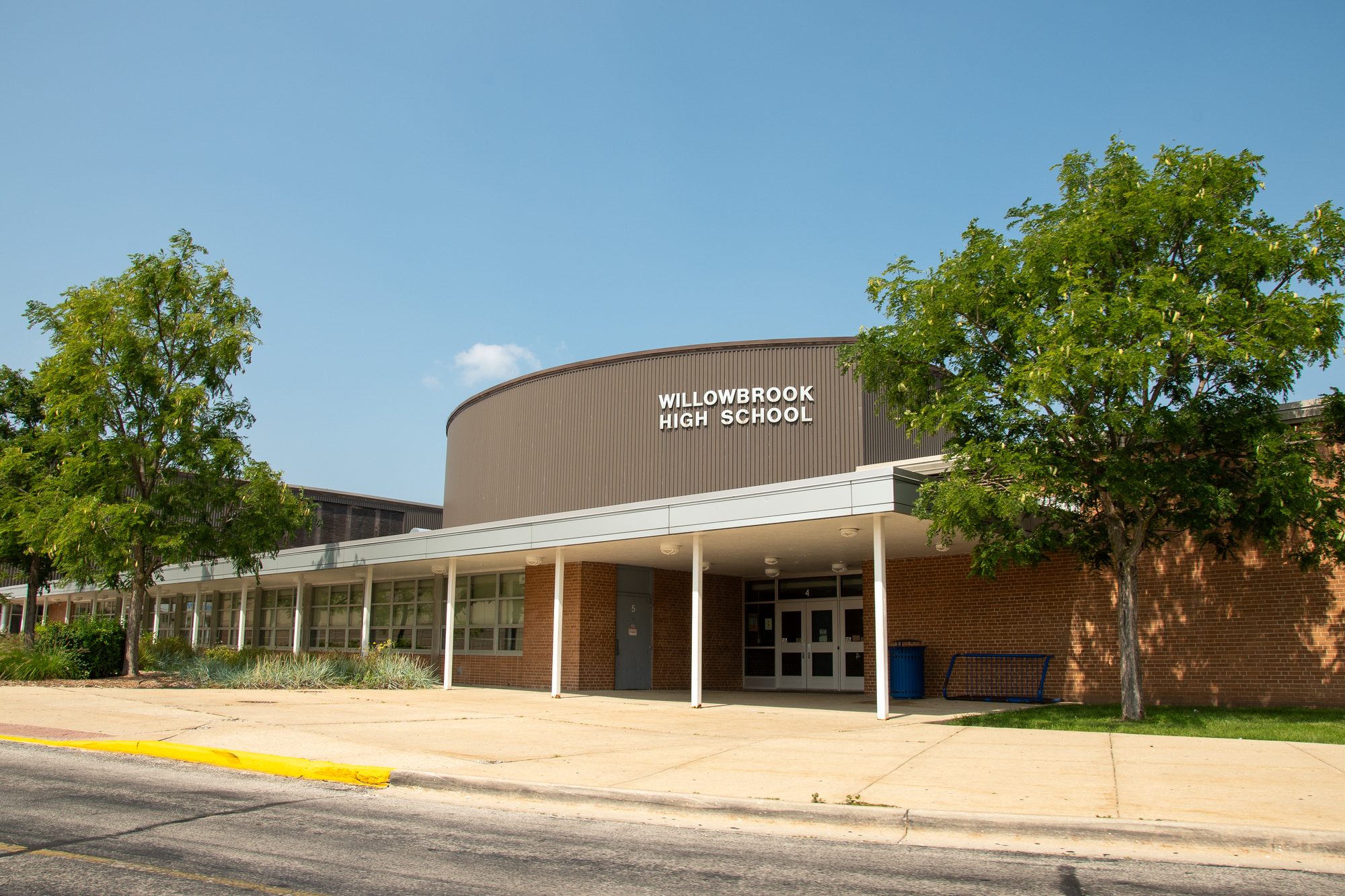 Curved brick facade of a high school building with the school name above the main entrance.