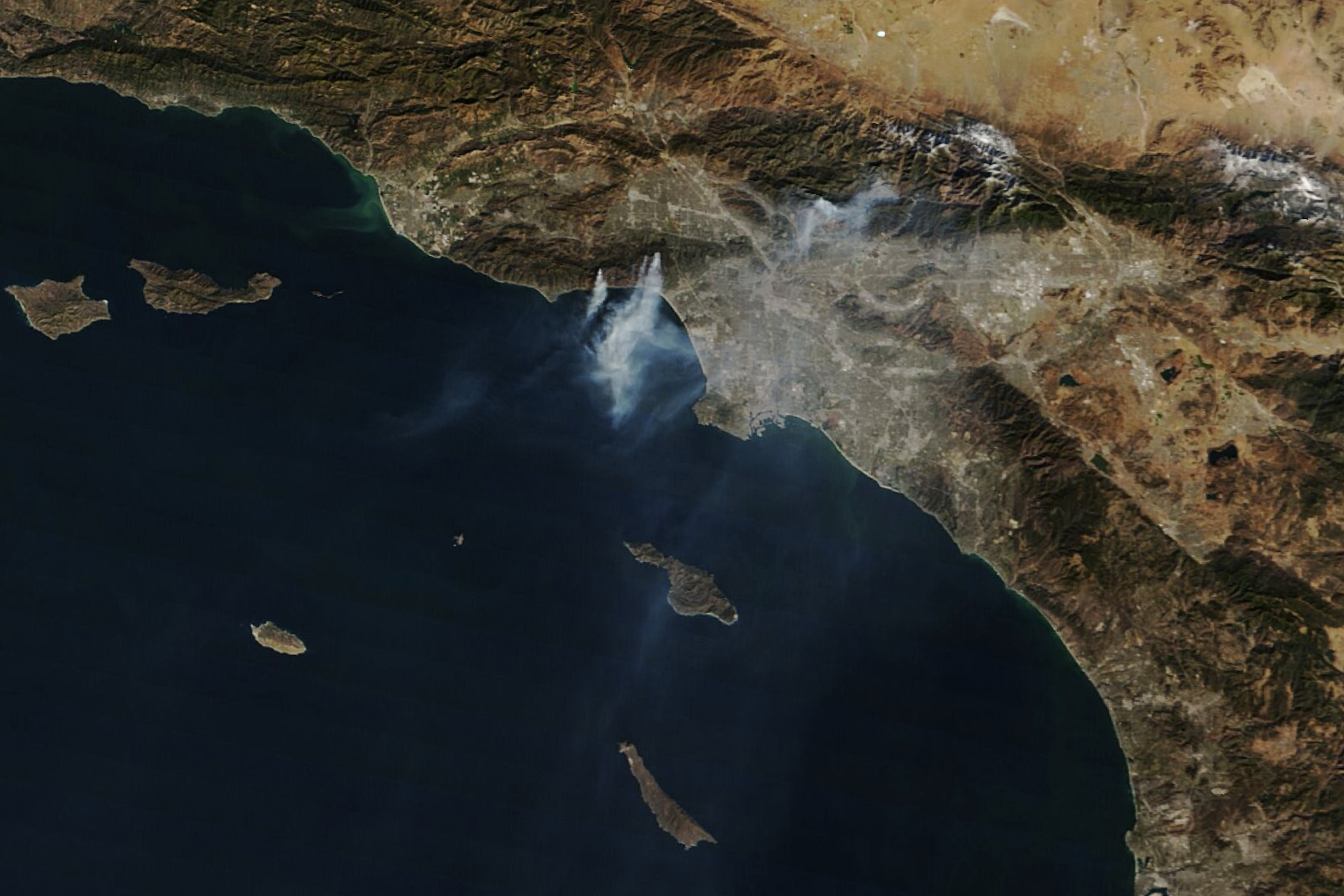Satellite view of smoke plumes streaming over the Pacific Ocean from Southern California wildfires.