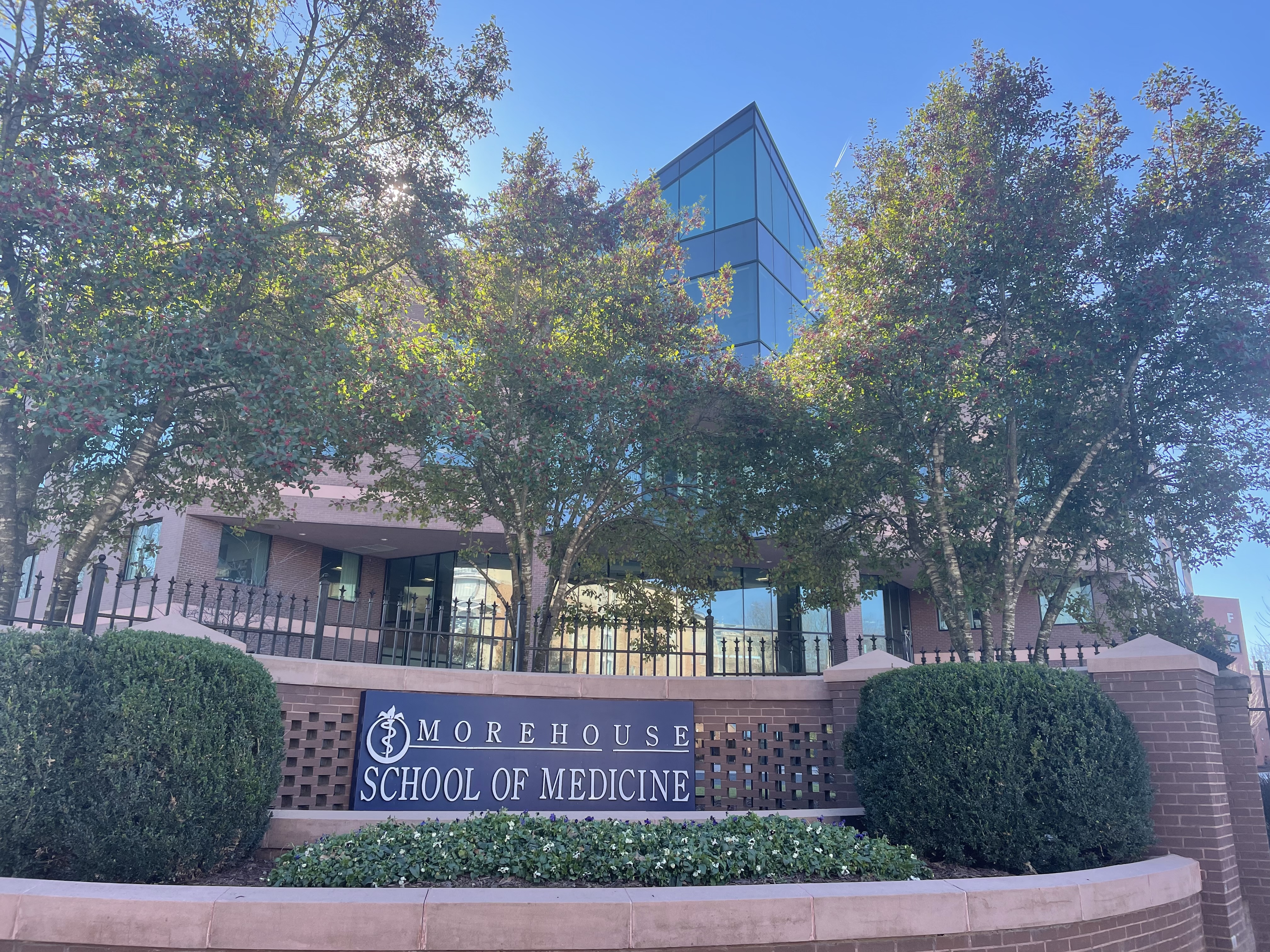 Entrance sign and brick building of Morehouse School of Medicine on a sunny day.