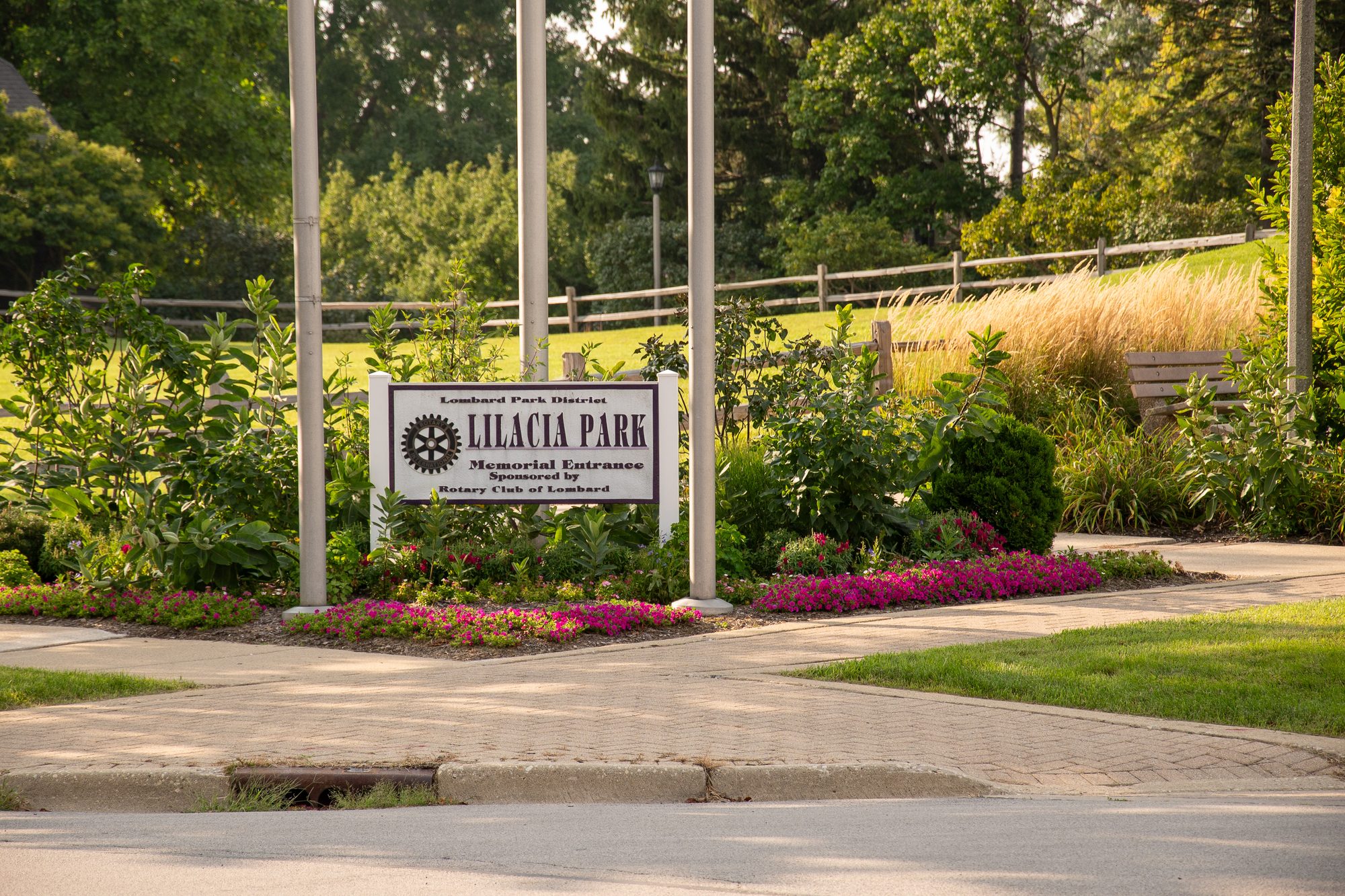 Park entrance sign surrounded by colorful flower beds and ornamental plantings.