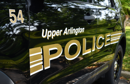 Close-up of an Upper Arlington Police Department vehicle door with gold lettering.