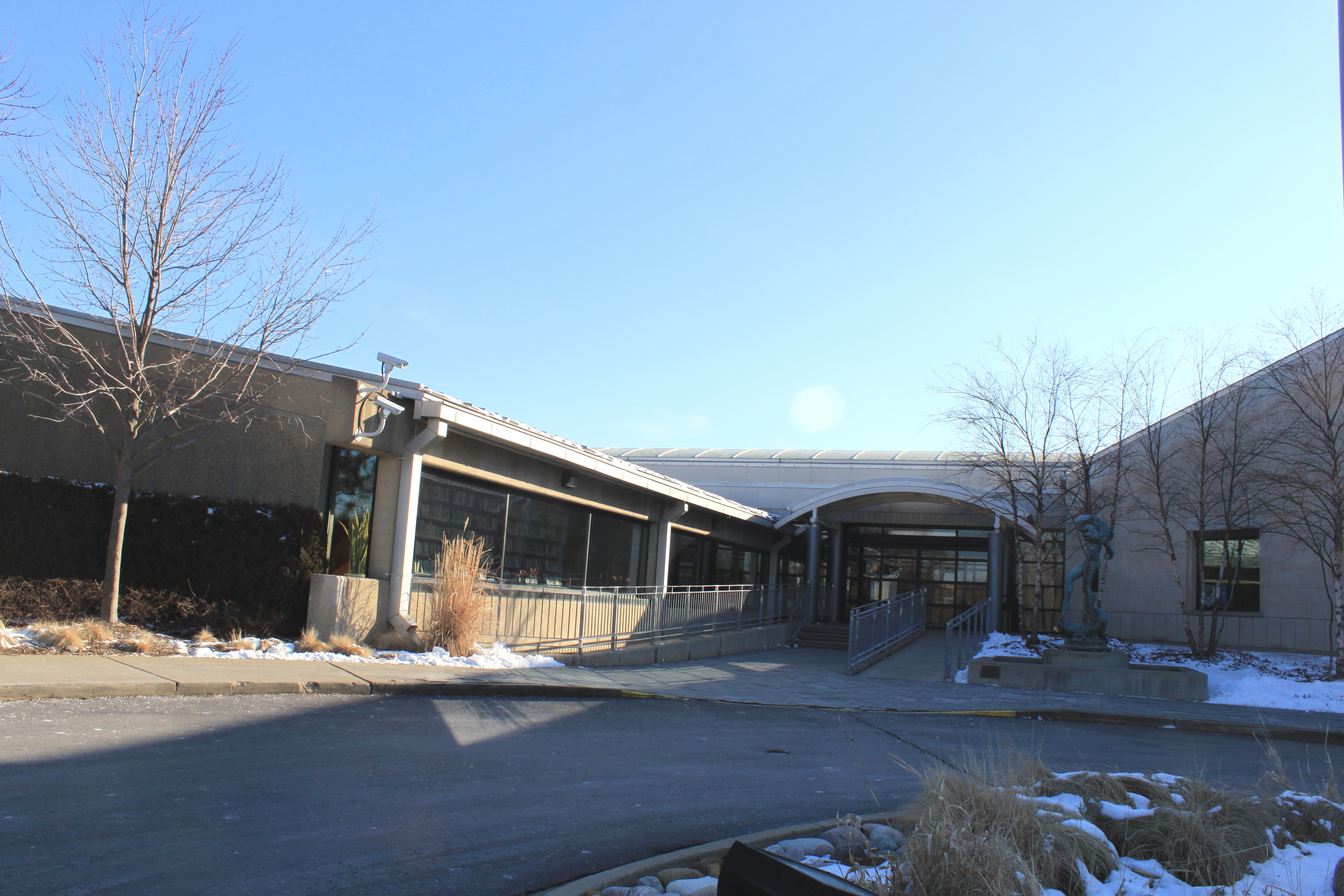 Single-story public library building with large windows and a covered entrance in winter.