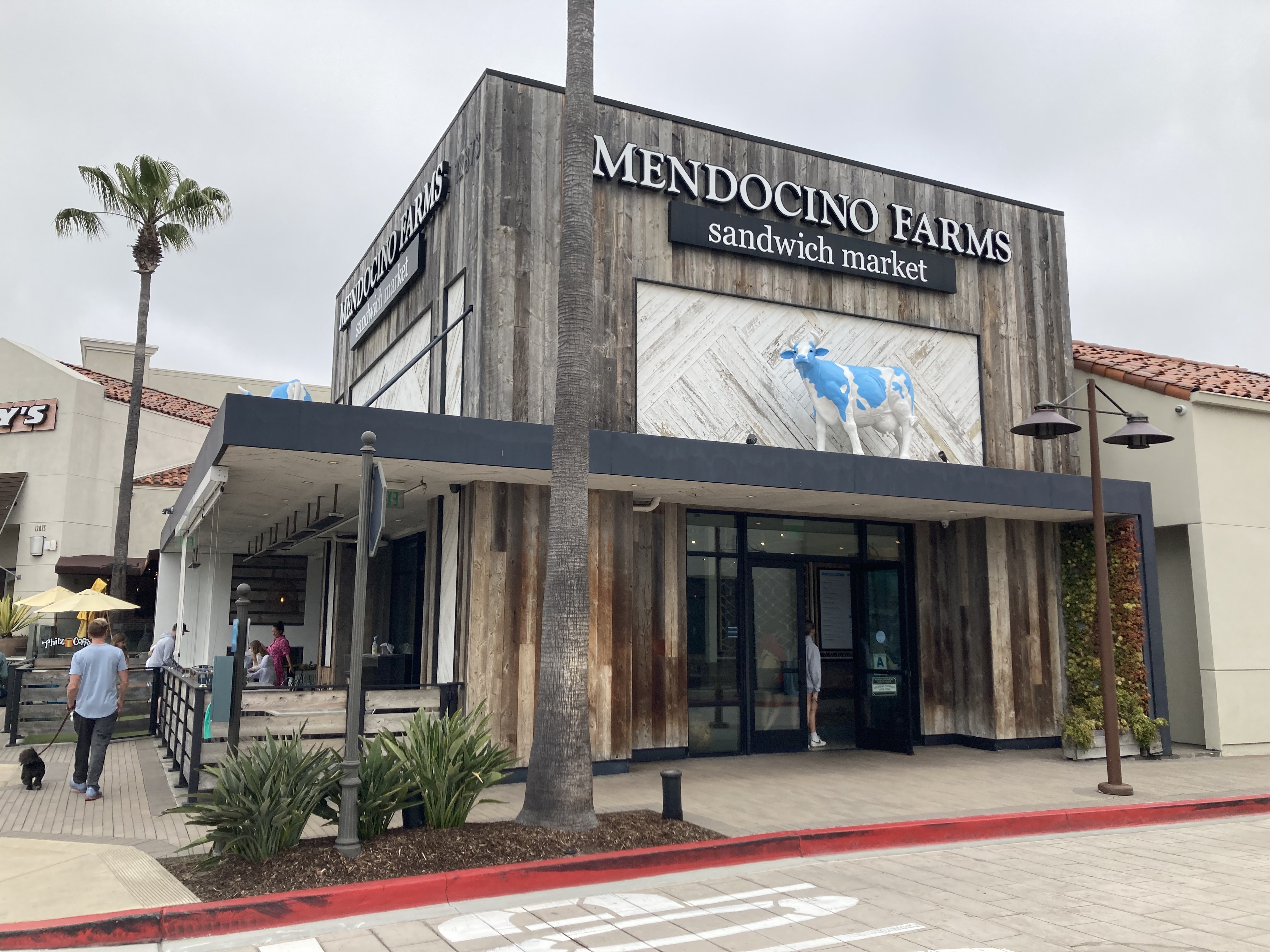 Exterior of a Mendocino Farms restaurant with wood-paneled facade and branded signage.
