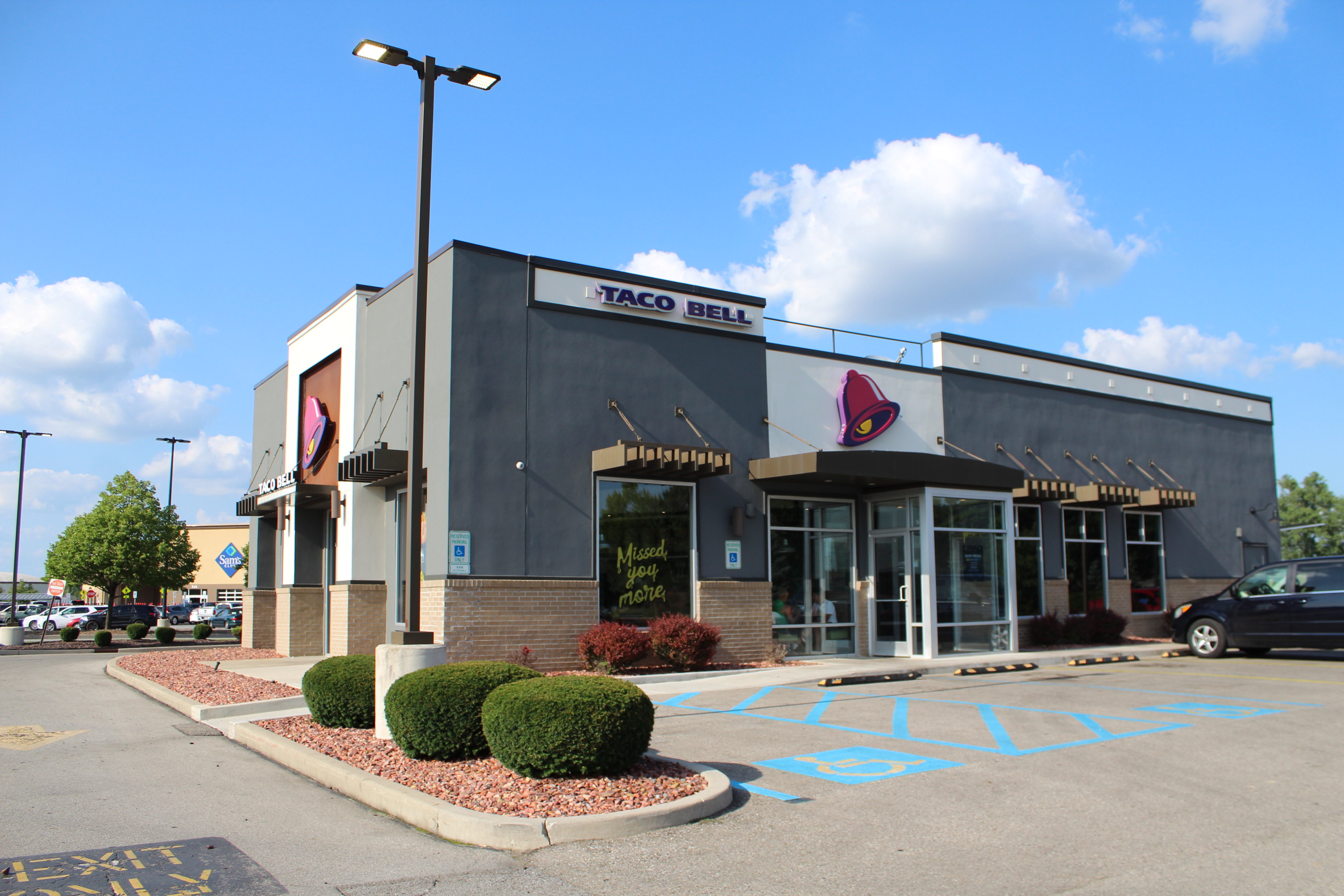 Exterior of a Taco Bell restaurant with signage, parking lot, and landscaping.