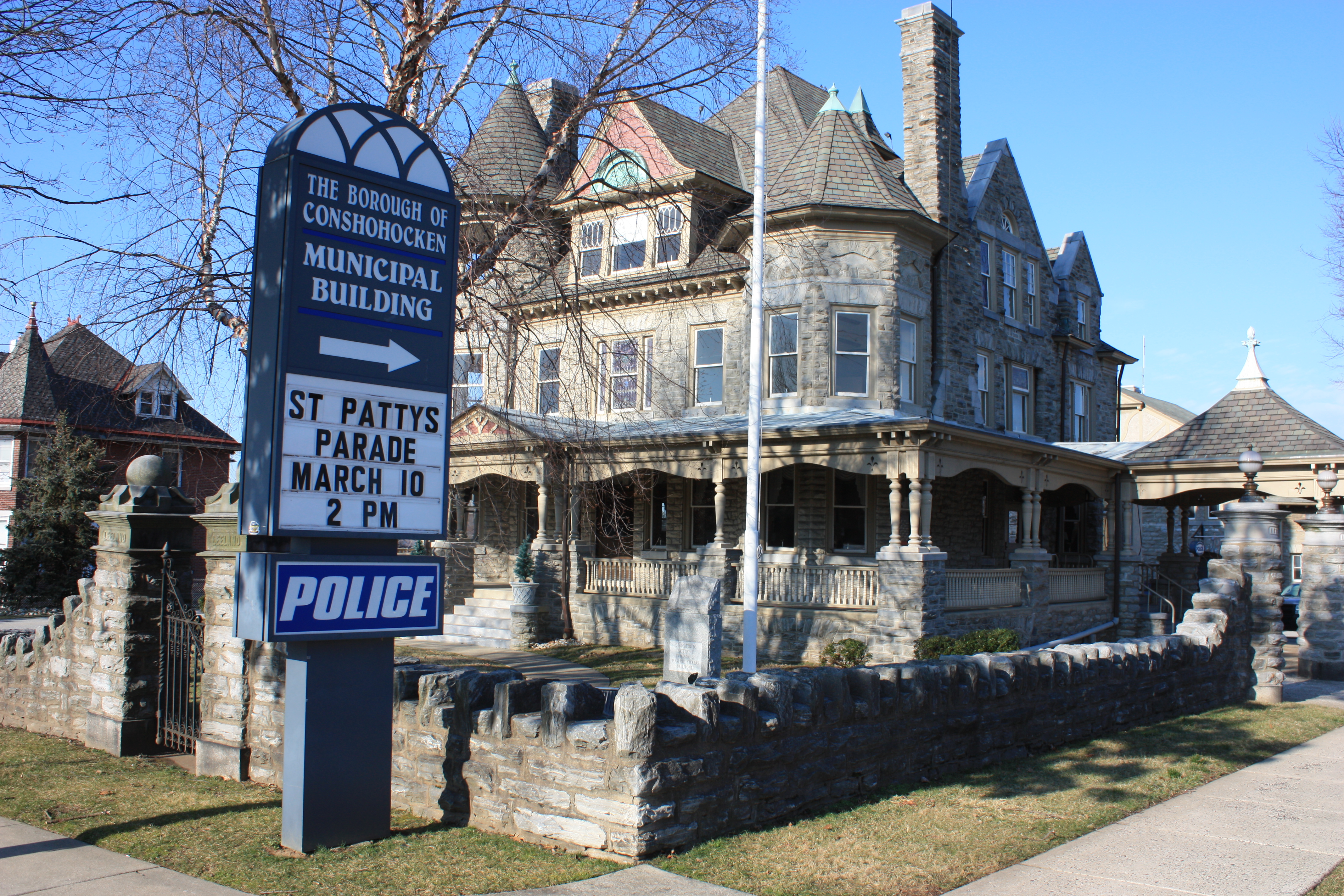 Victorian stone municipal building with a blue Police sign in the foreground.