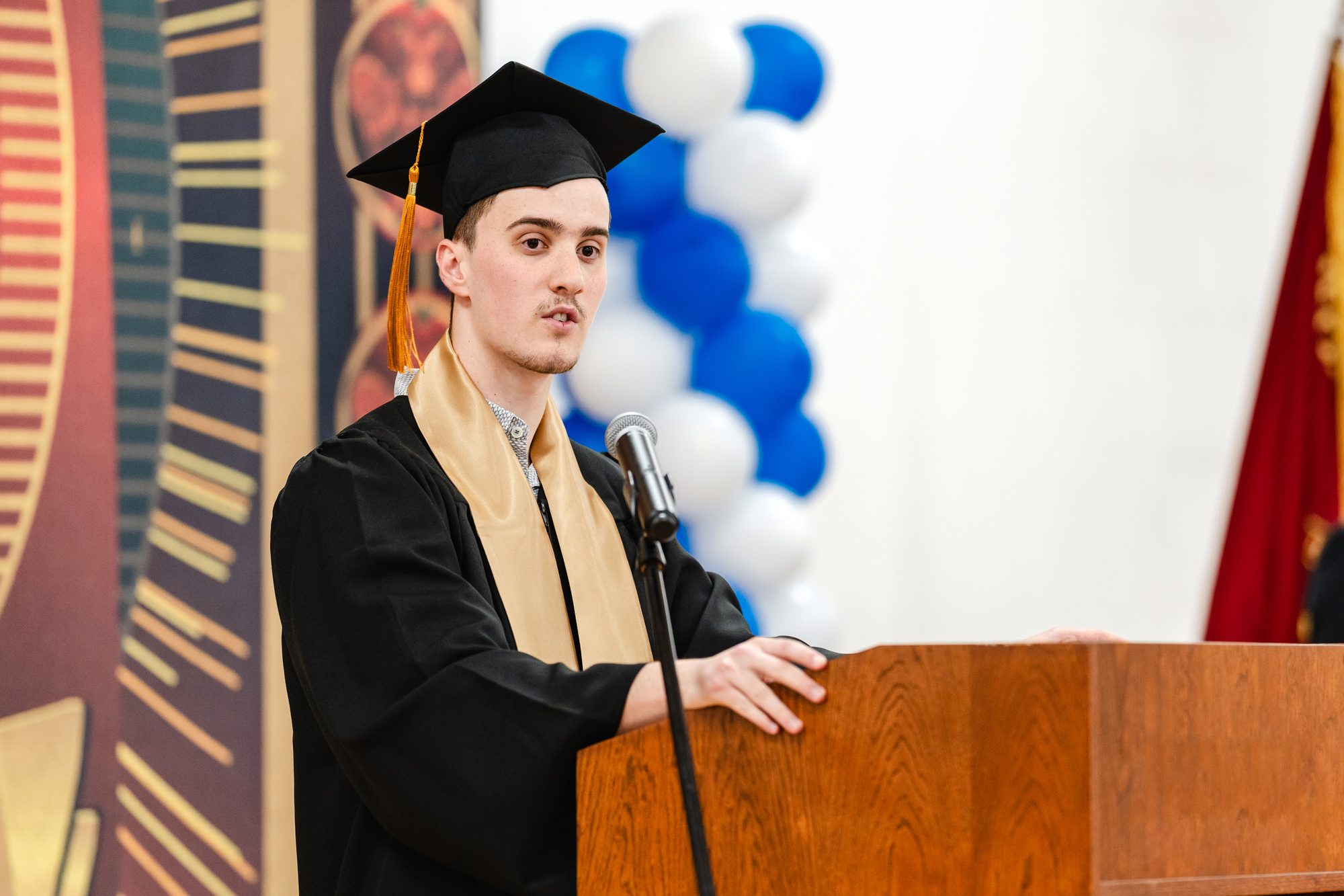 High school senior giving a speech in his graduation ceremony