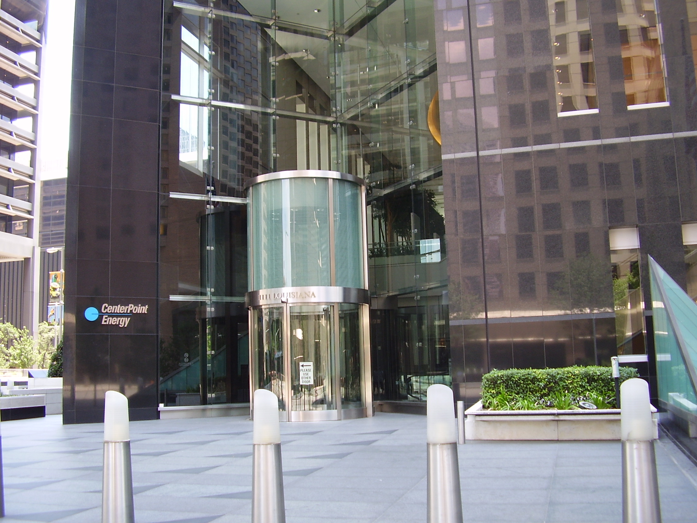 Exterior of a glass office building with a CenterPoint Energy sign at the entrance.