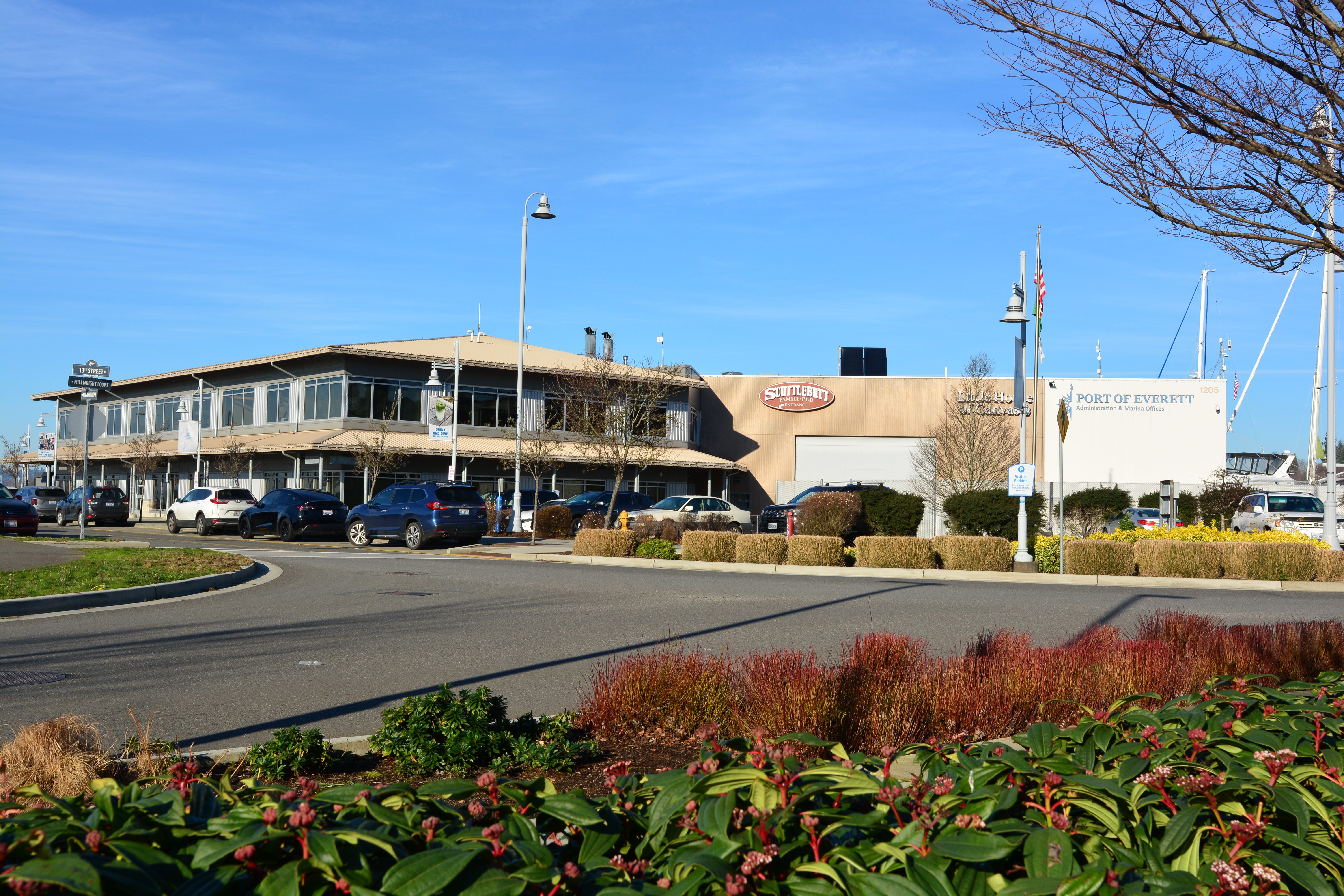 Two-story waterfront building housing Port of Everett offices, with sailboat masts behind it.
