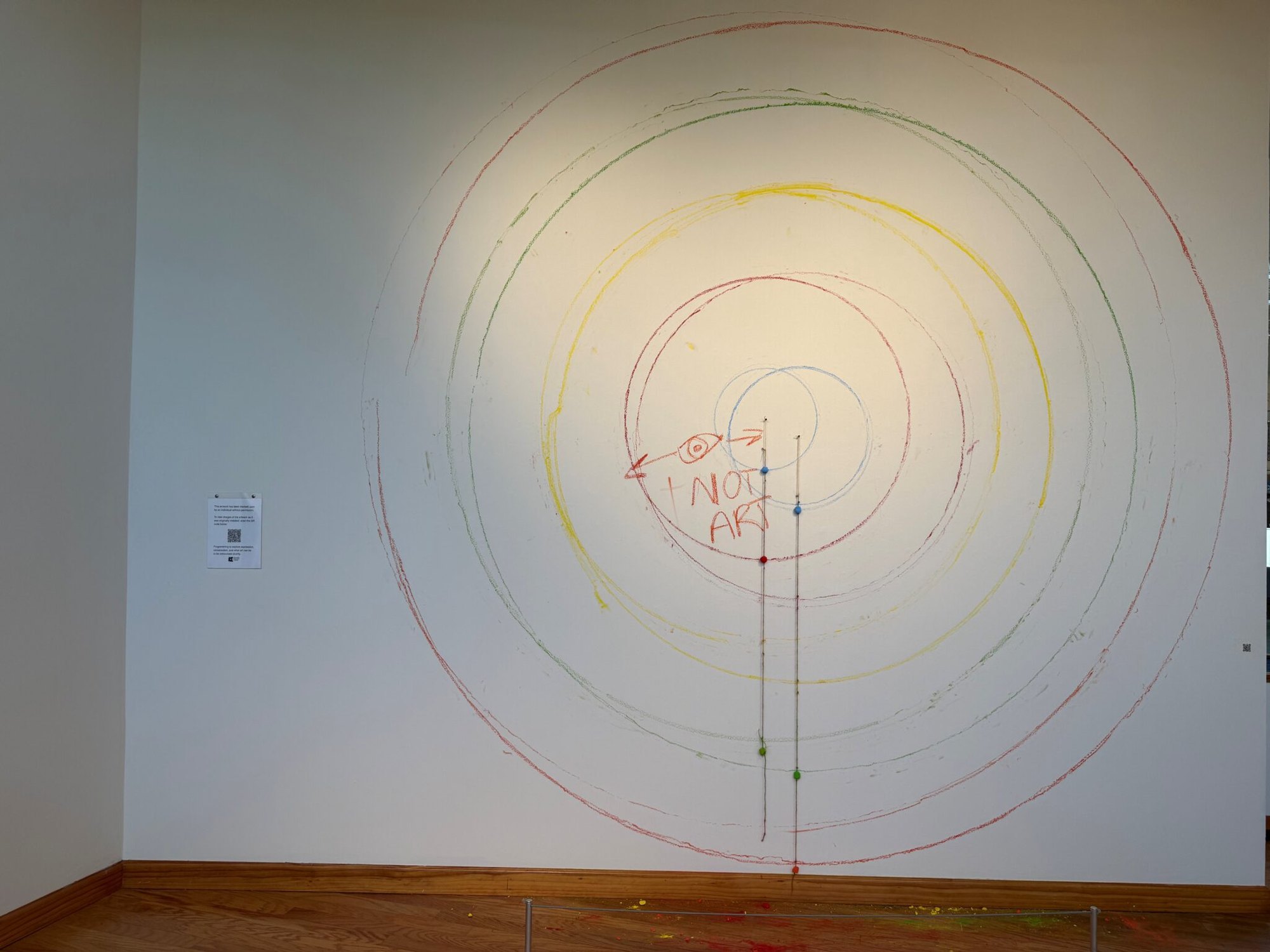 Large circular pastel wall installation with handwritten 'NOT ART' text visible at center.