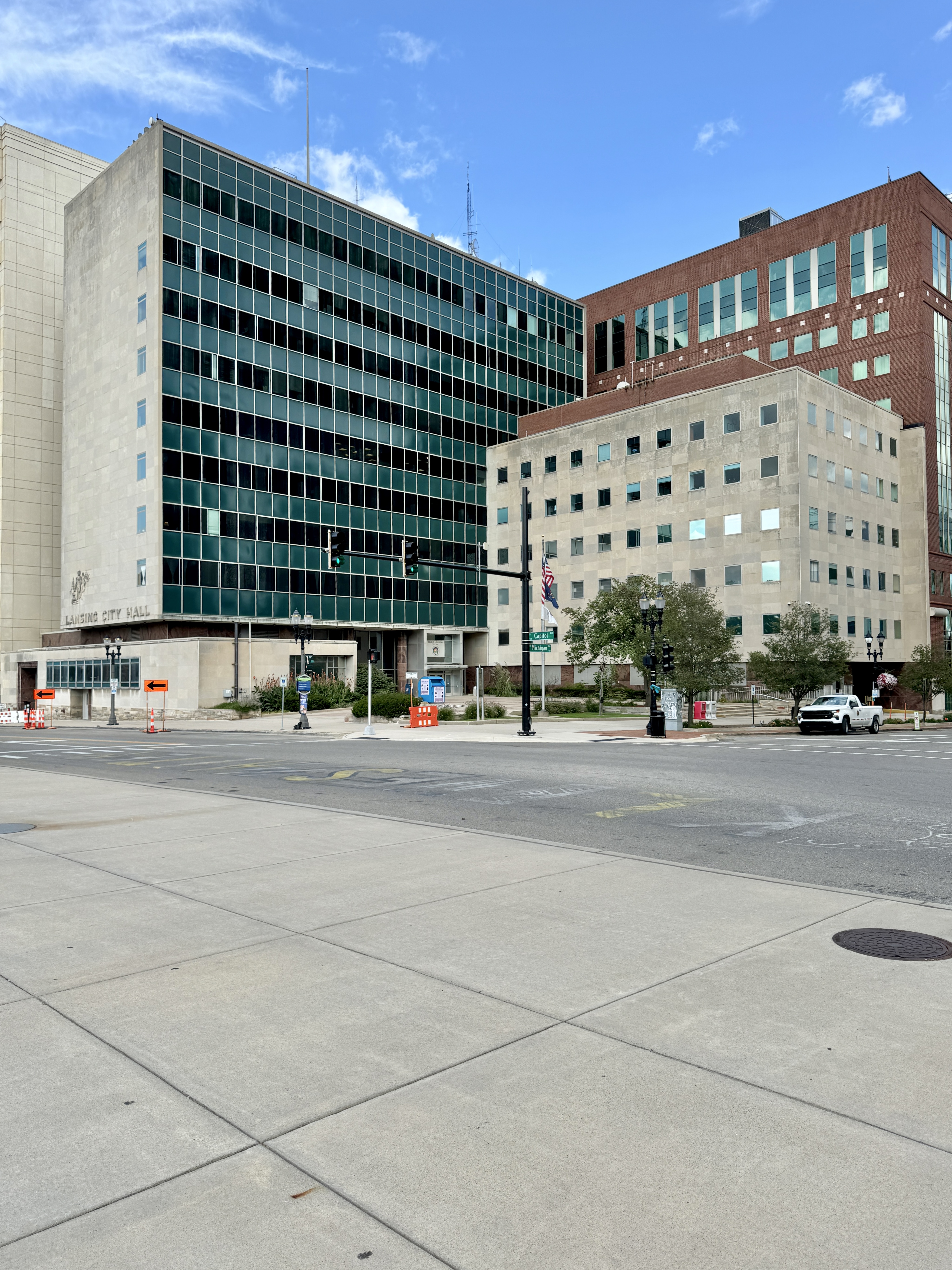 Limestone and glass government building with 'Lansing City Hall' carved into the facade.