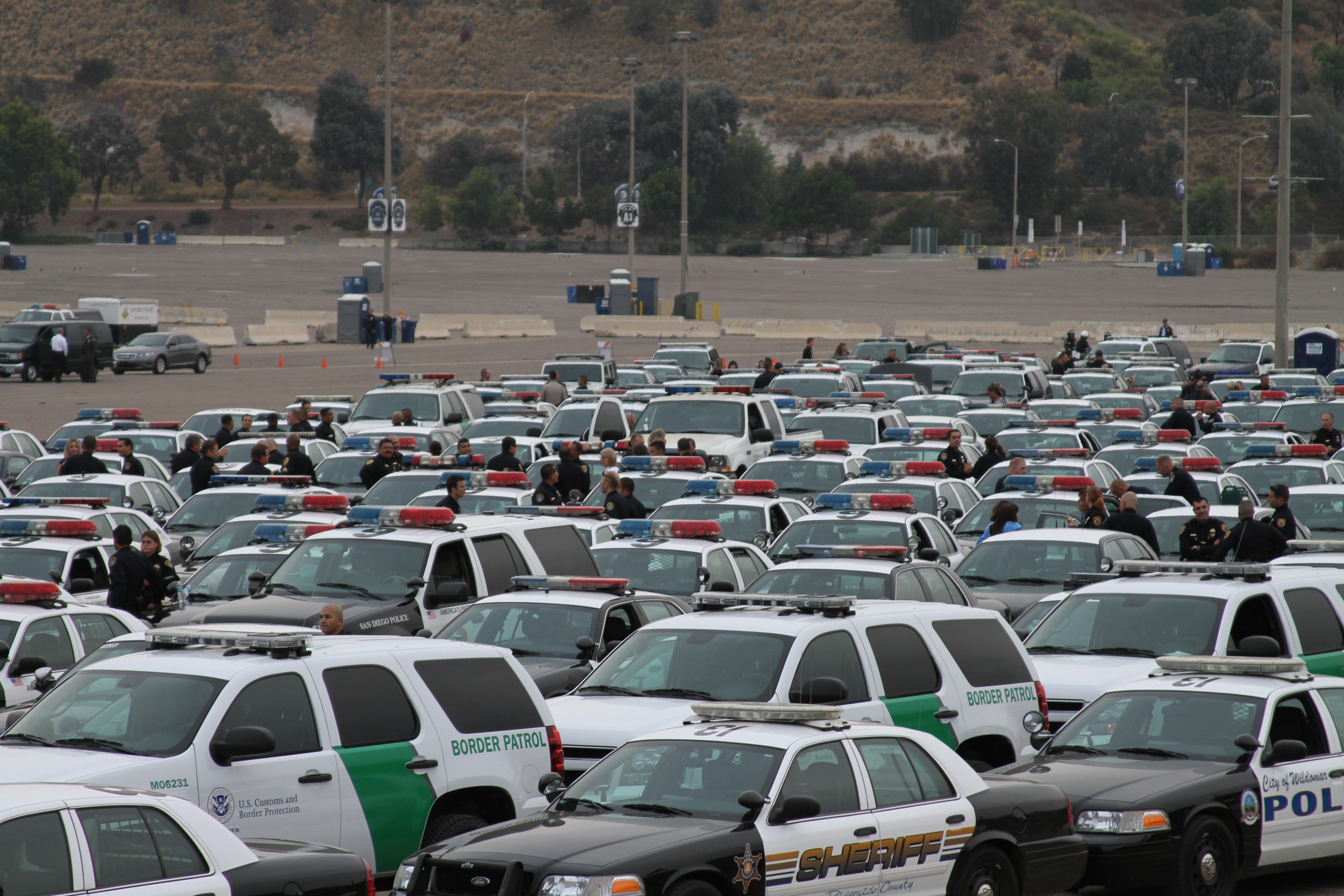 Rows of law enforcement patrol vehicles filling a large parking lot.