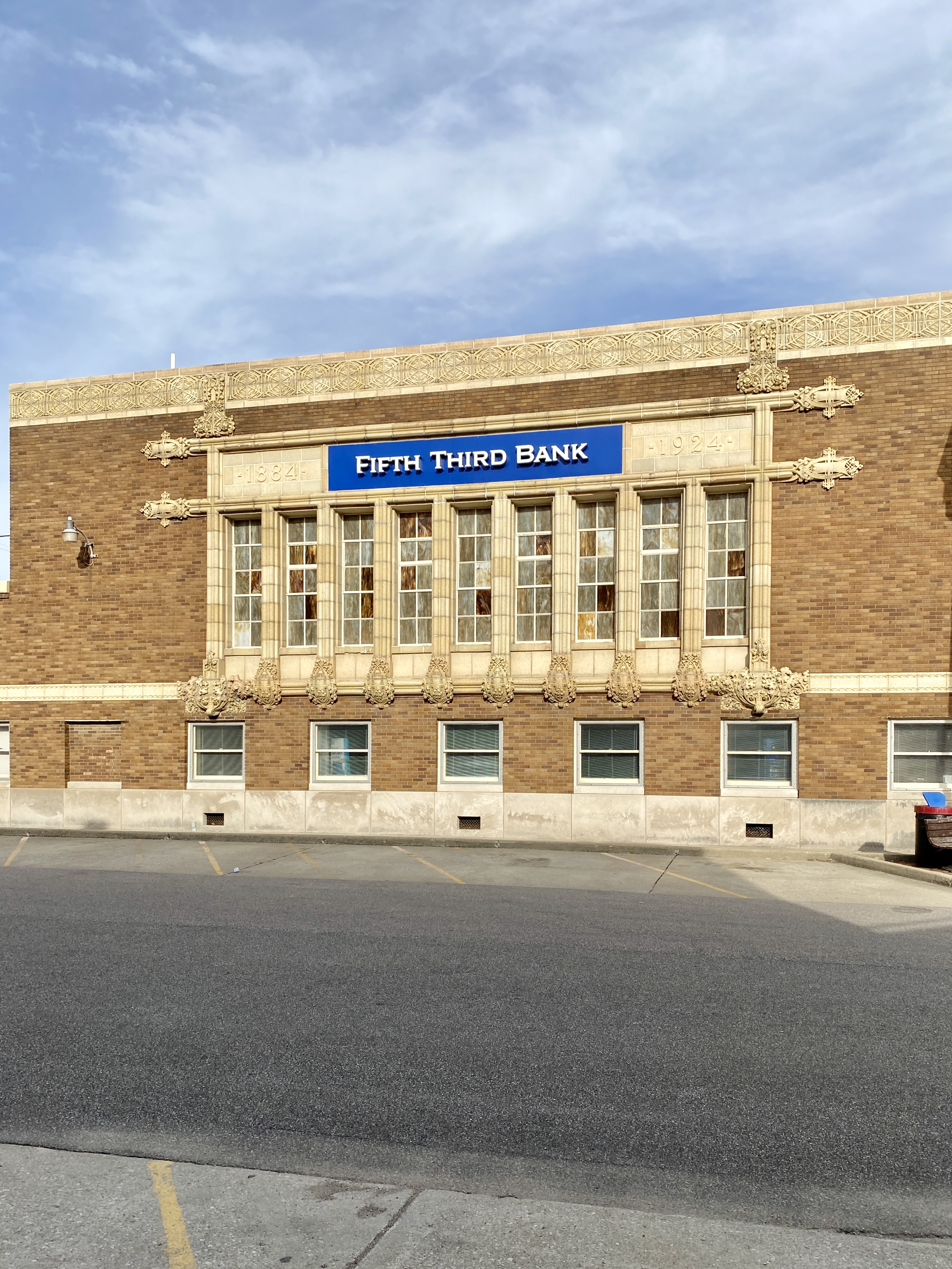 Close-up of a historic brick bank building facade with a blue Fifth Third Bank sign and decorative terra cotta trim.