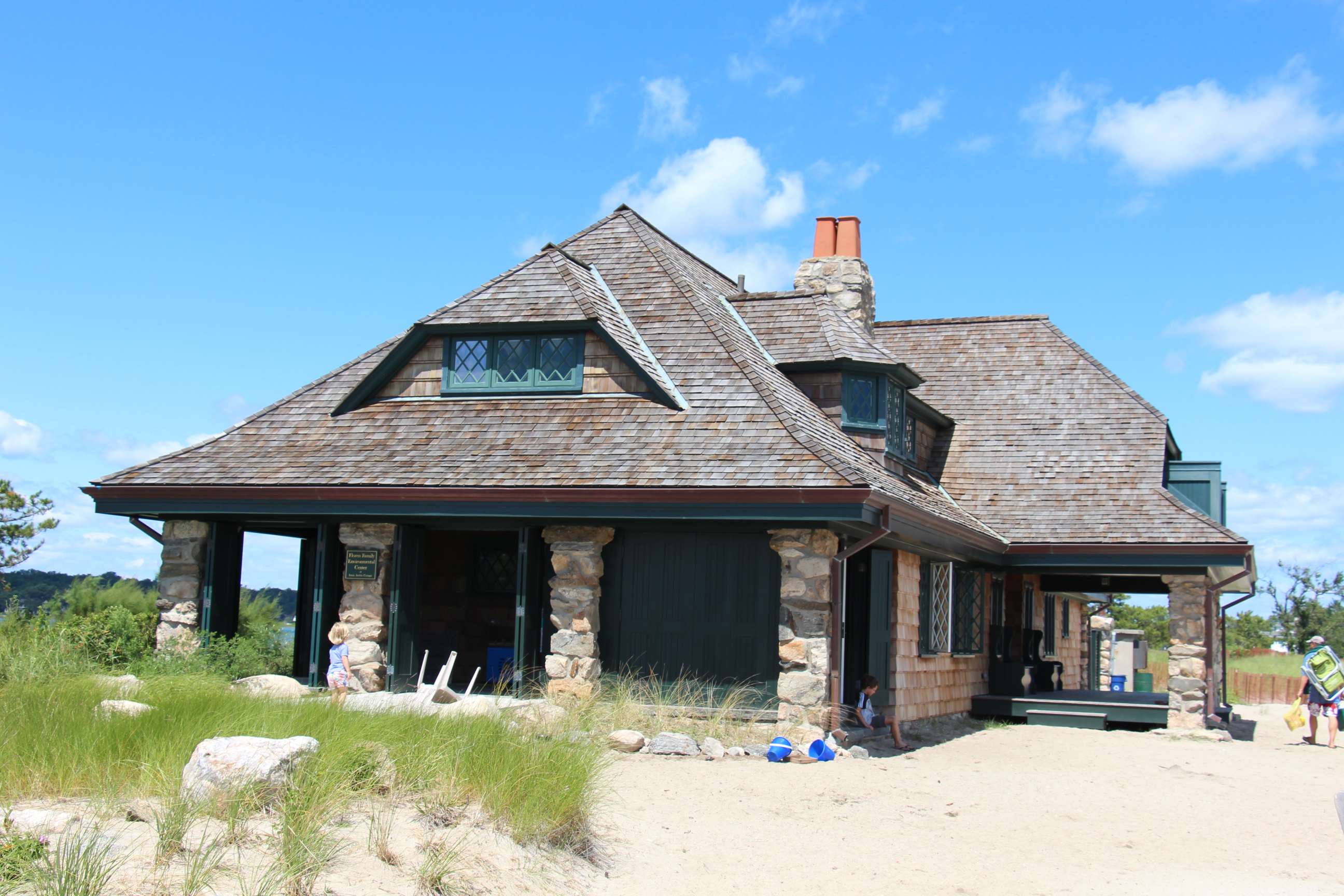 Stone pavilion building on a sandy beach at Greenwich Point Park on a sunny day.