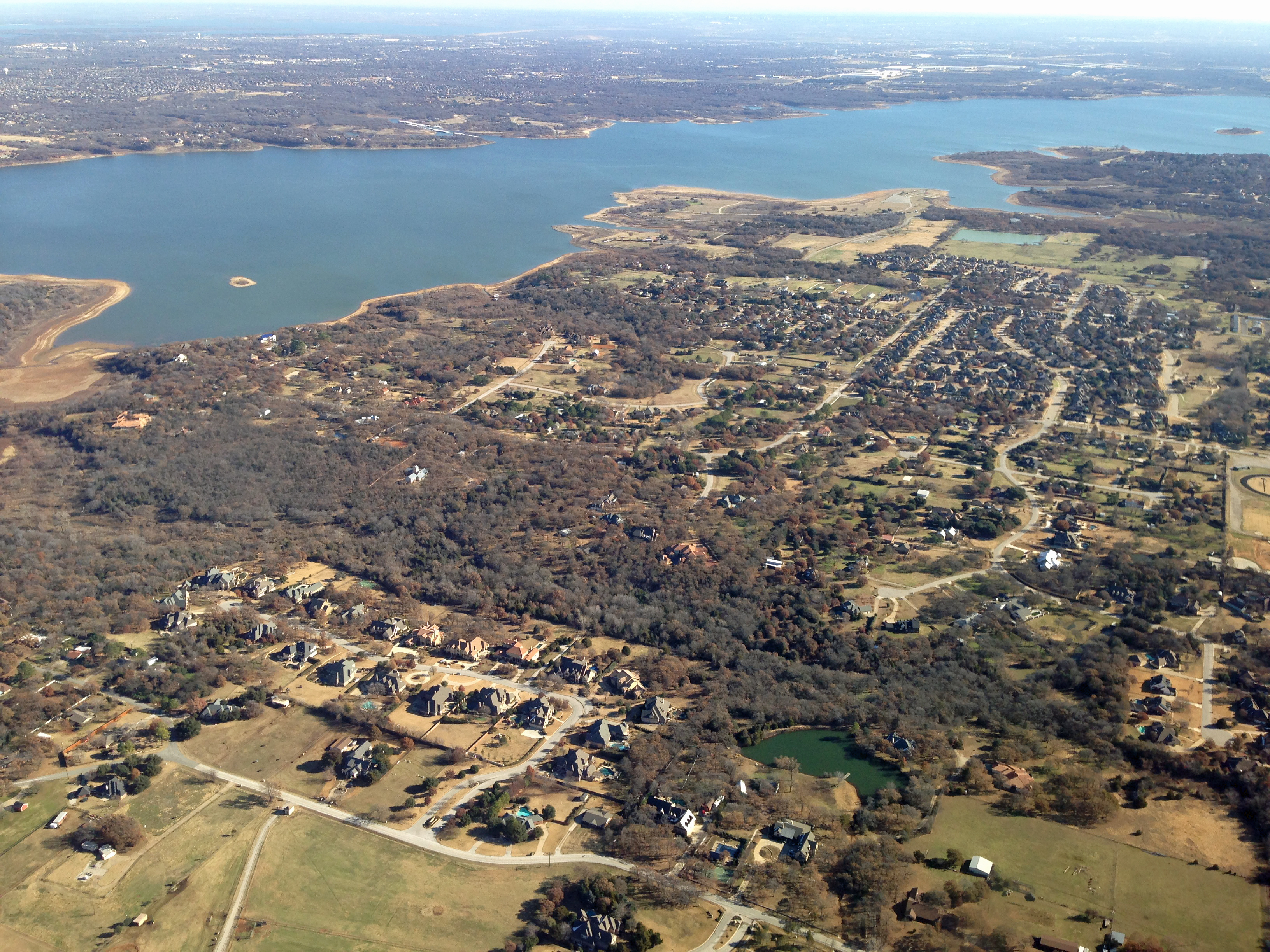 Aerial view of suburban Southlake neighborhoods with a large lake in the background.