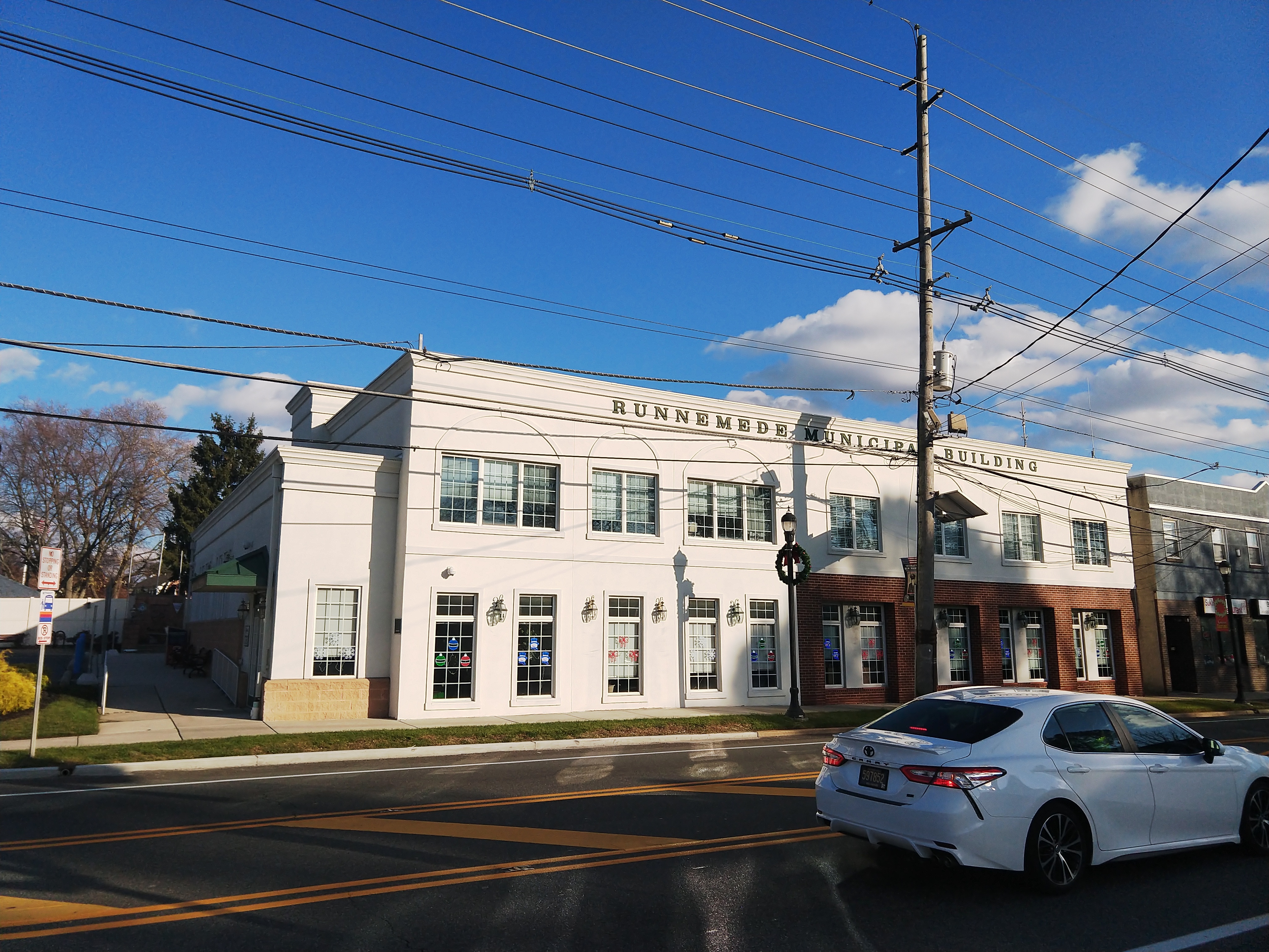 Two-story white municipal building with a sign reading Runnemede Municipal Building.