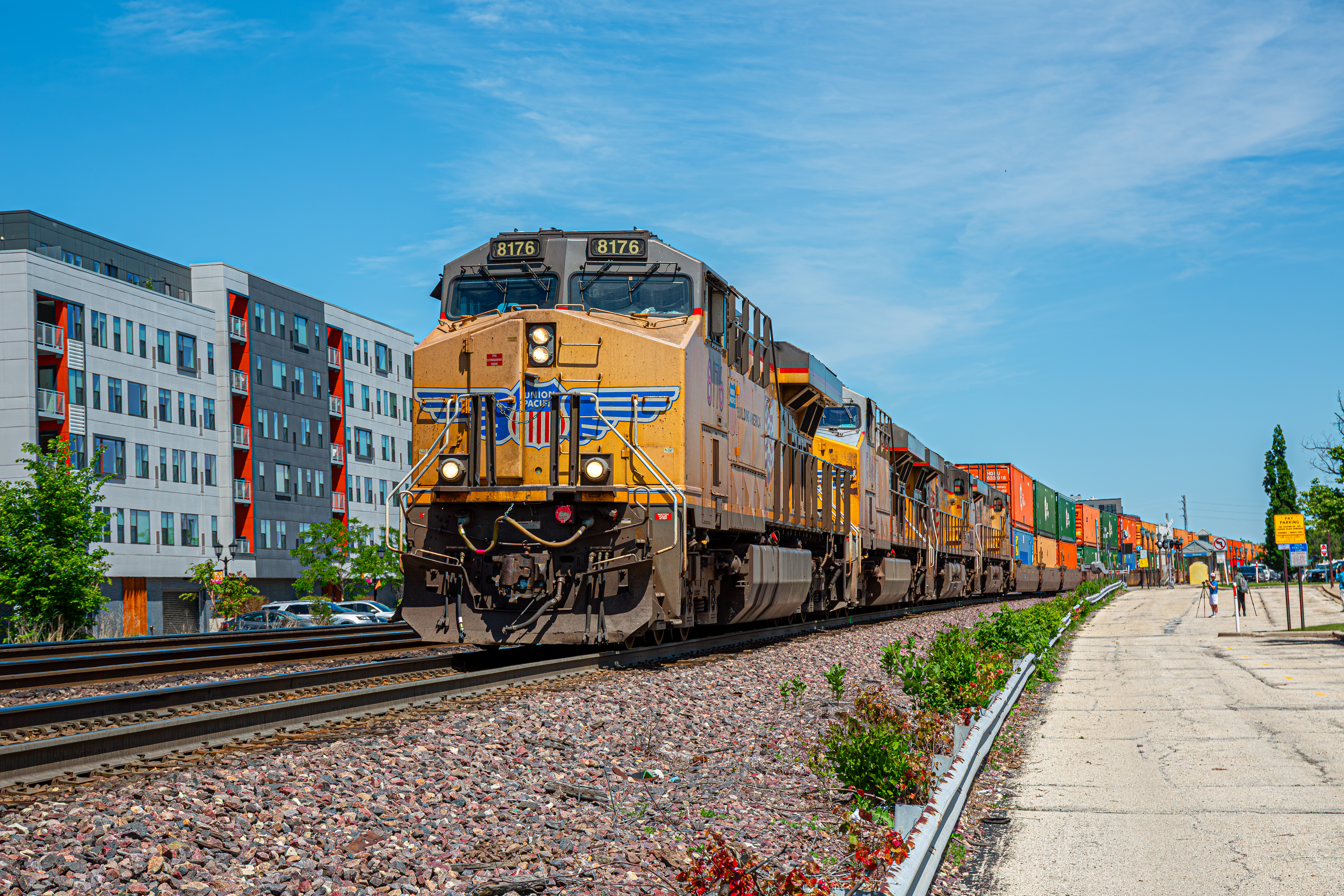 A Union Pacific freight train moving along suburban Illinois railroad tracks.