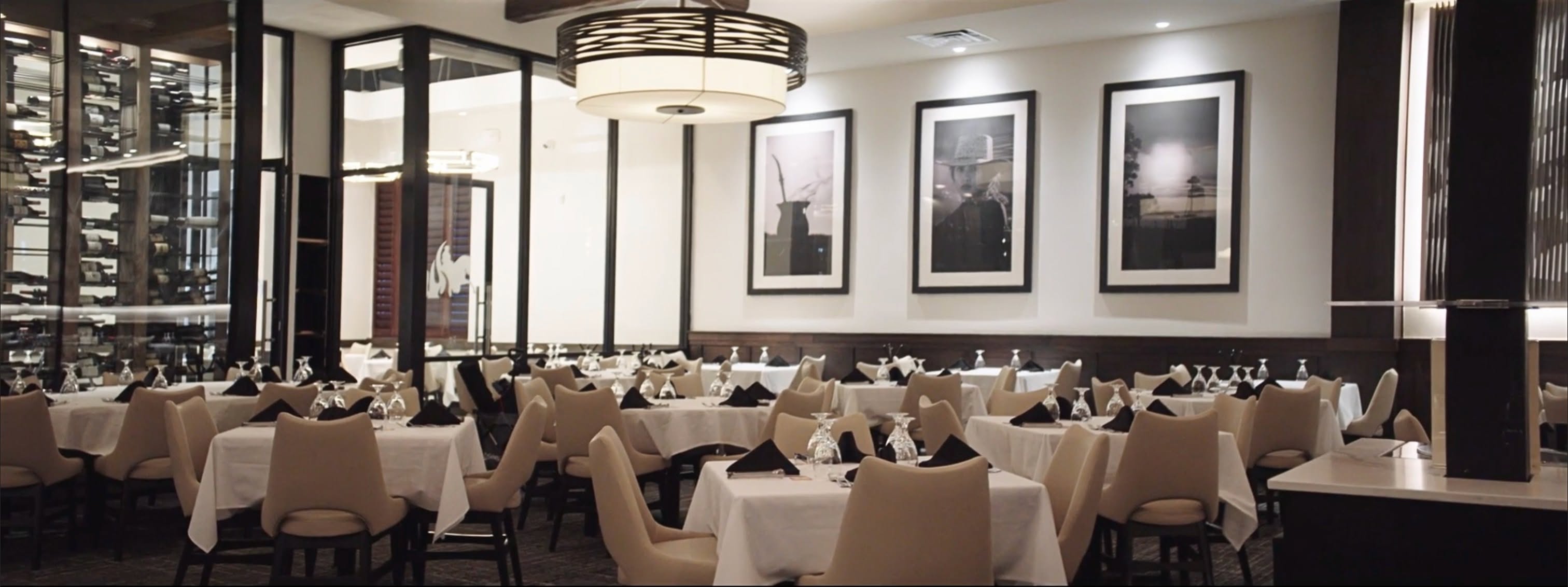 Empty restaurant with tables and place settings ready for people to dine.