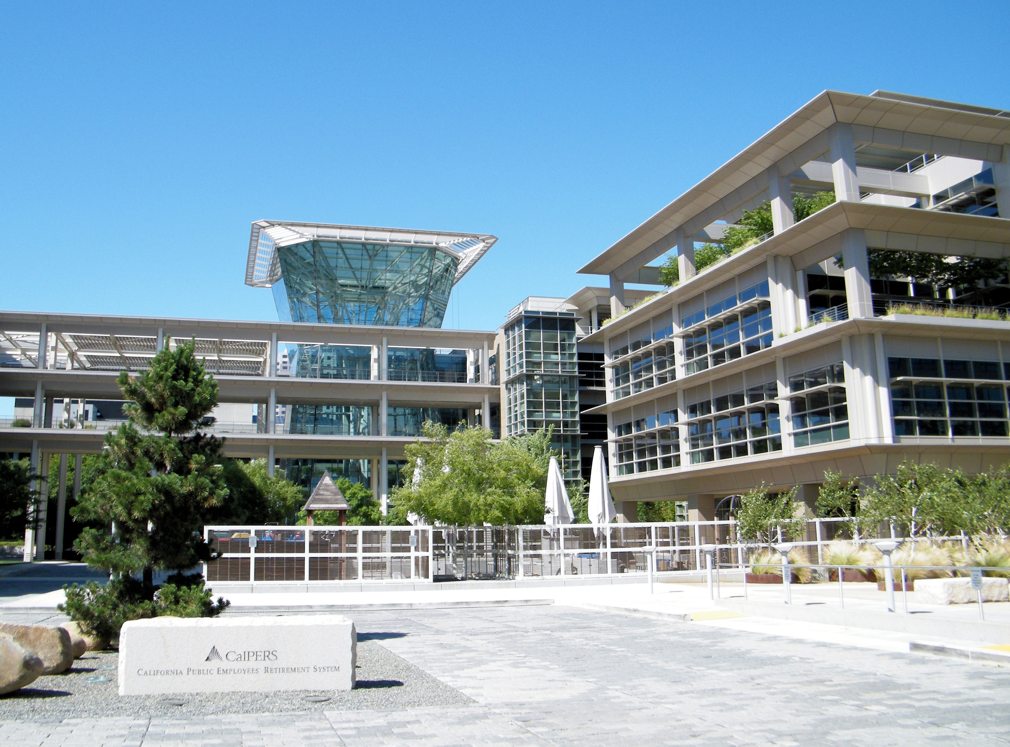 Glass office complex with a sign reading CalPERS California Public Employees Retirement System.