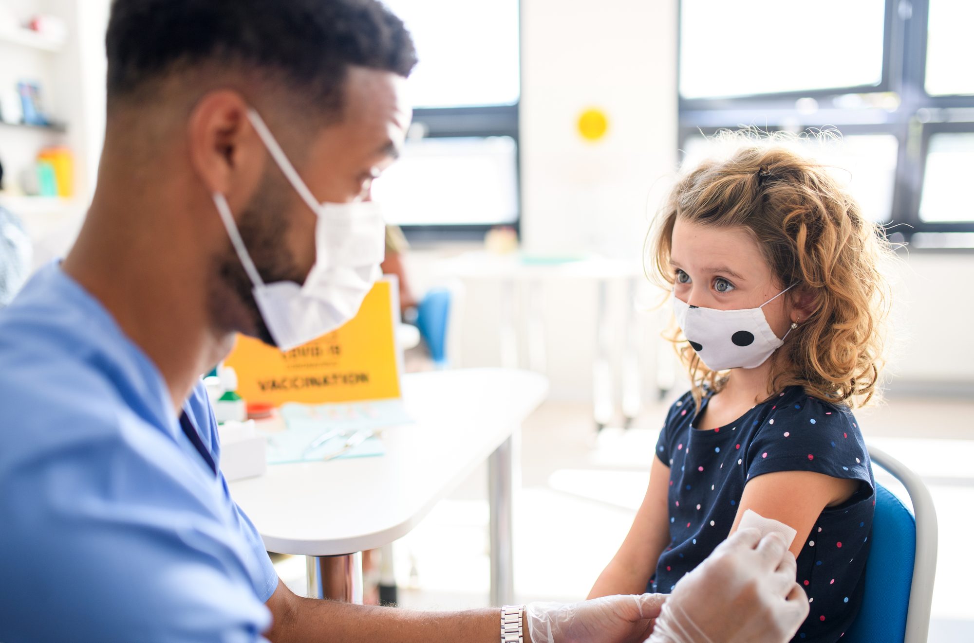 Child with face mask getting vaccinated, coronavirus, covid-19 and vaccination concept.