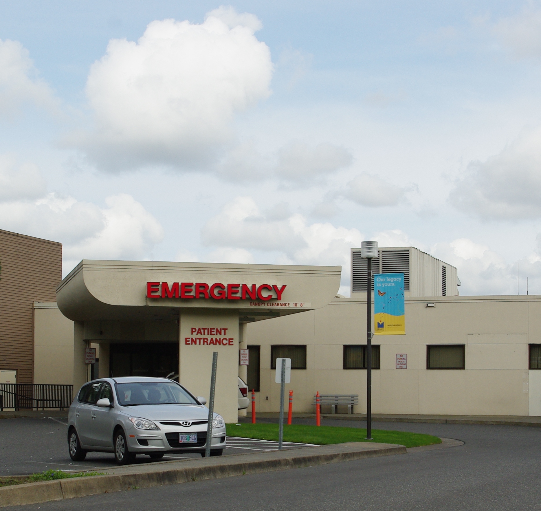 Hospital emergency entrance with red Emergency sign and covered drive-up canopy.