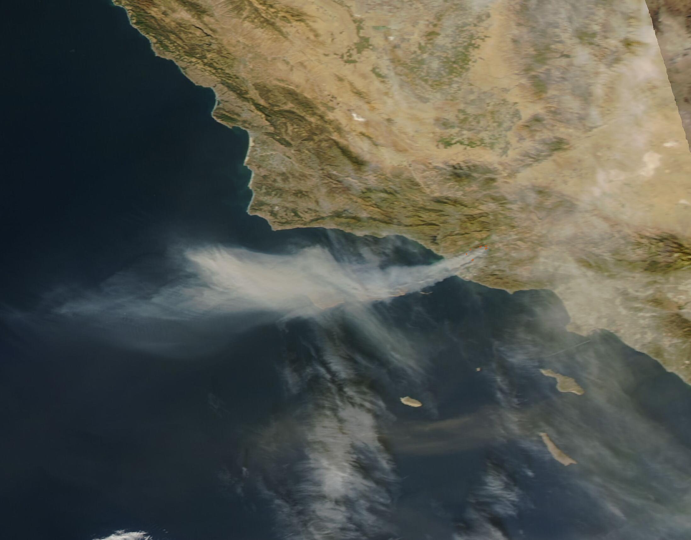 Satellite image showing wildfire smoke spreading over the Southern California coast and ocean.