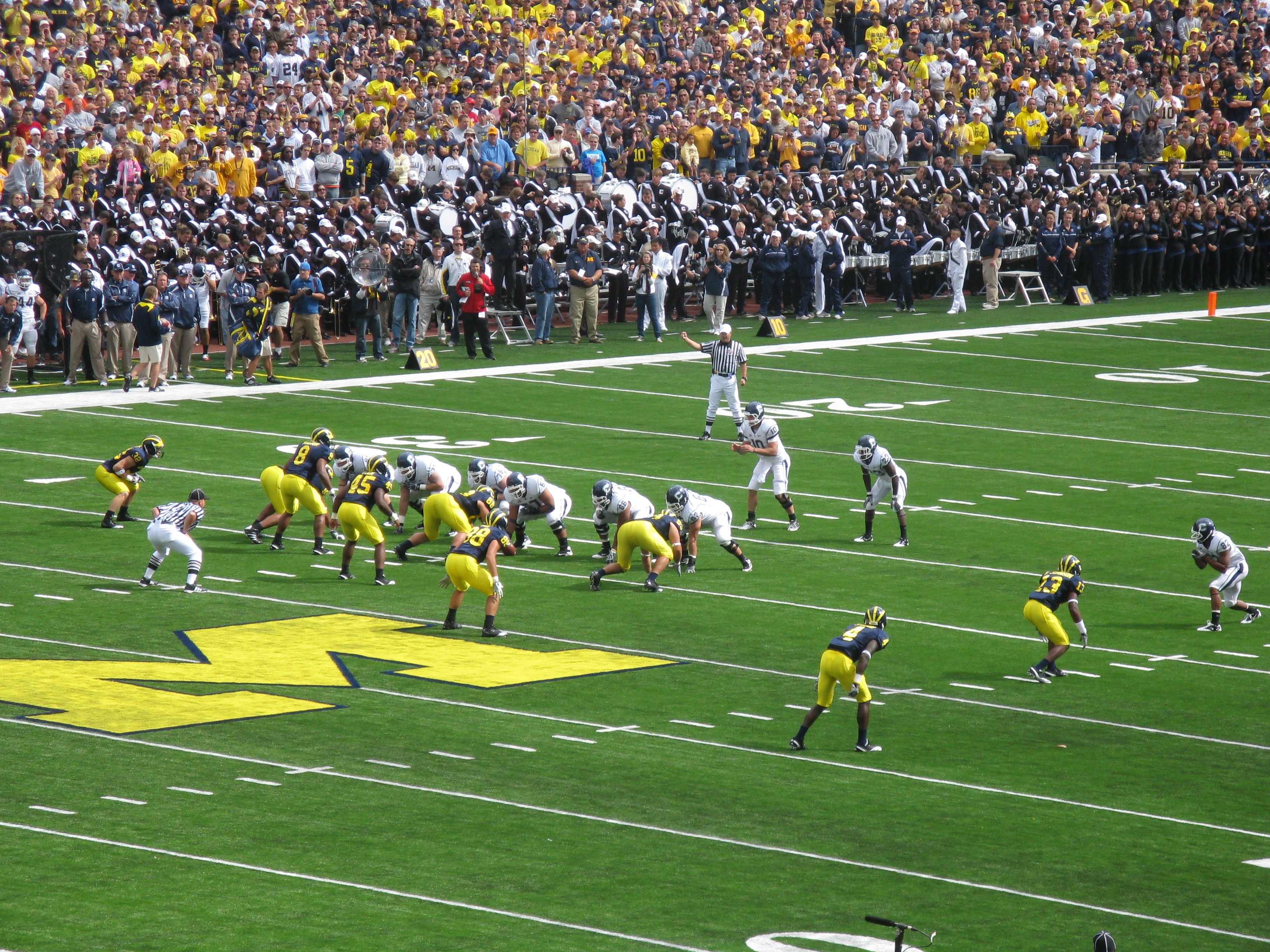 Michigan Wolverines football players lined up at the line of scrimmage during a game.