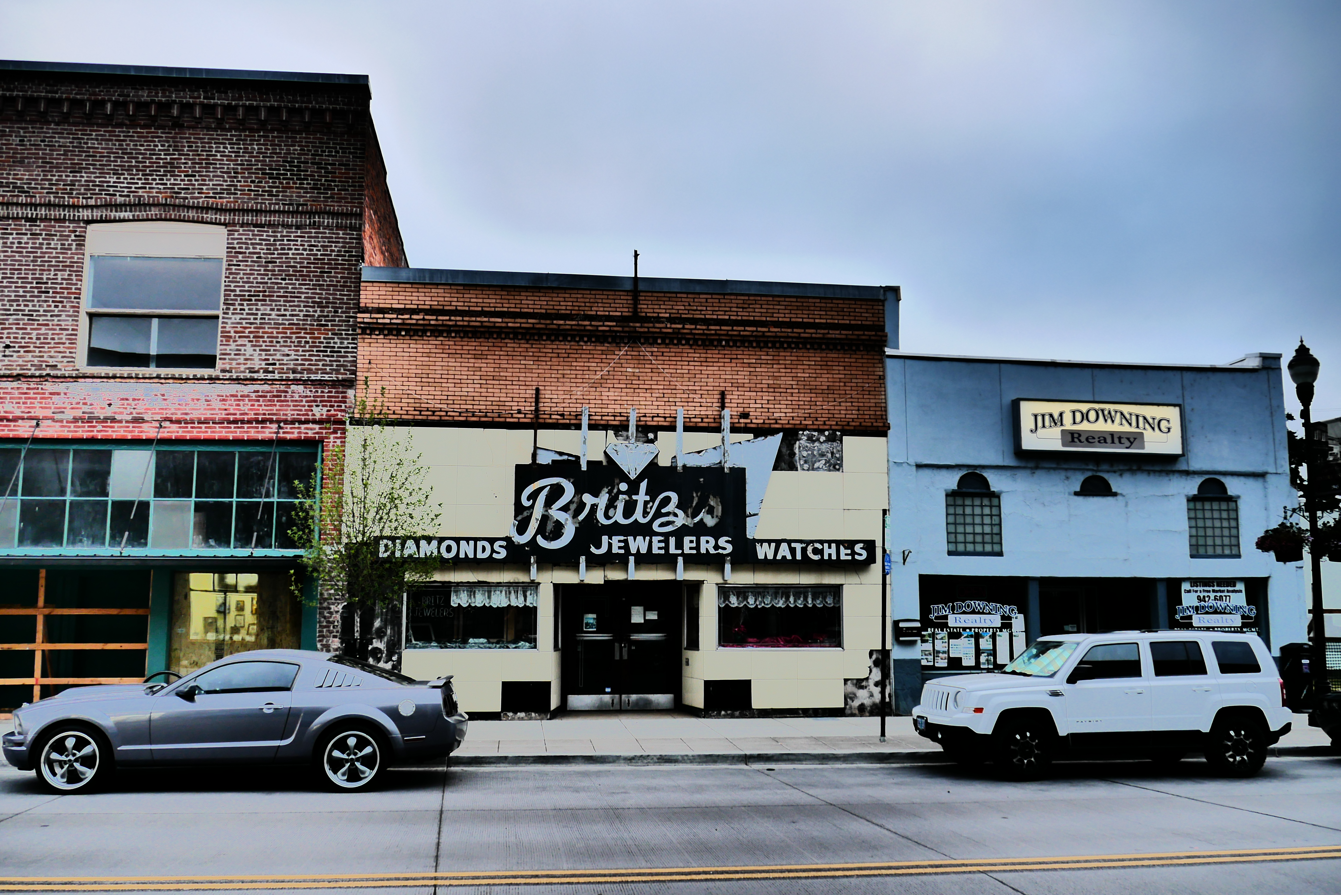 Two adjacent brick and painted storefronts on a downtown street in Cottage Grove, Oregon.