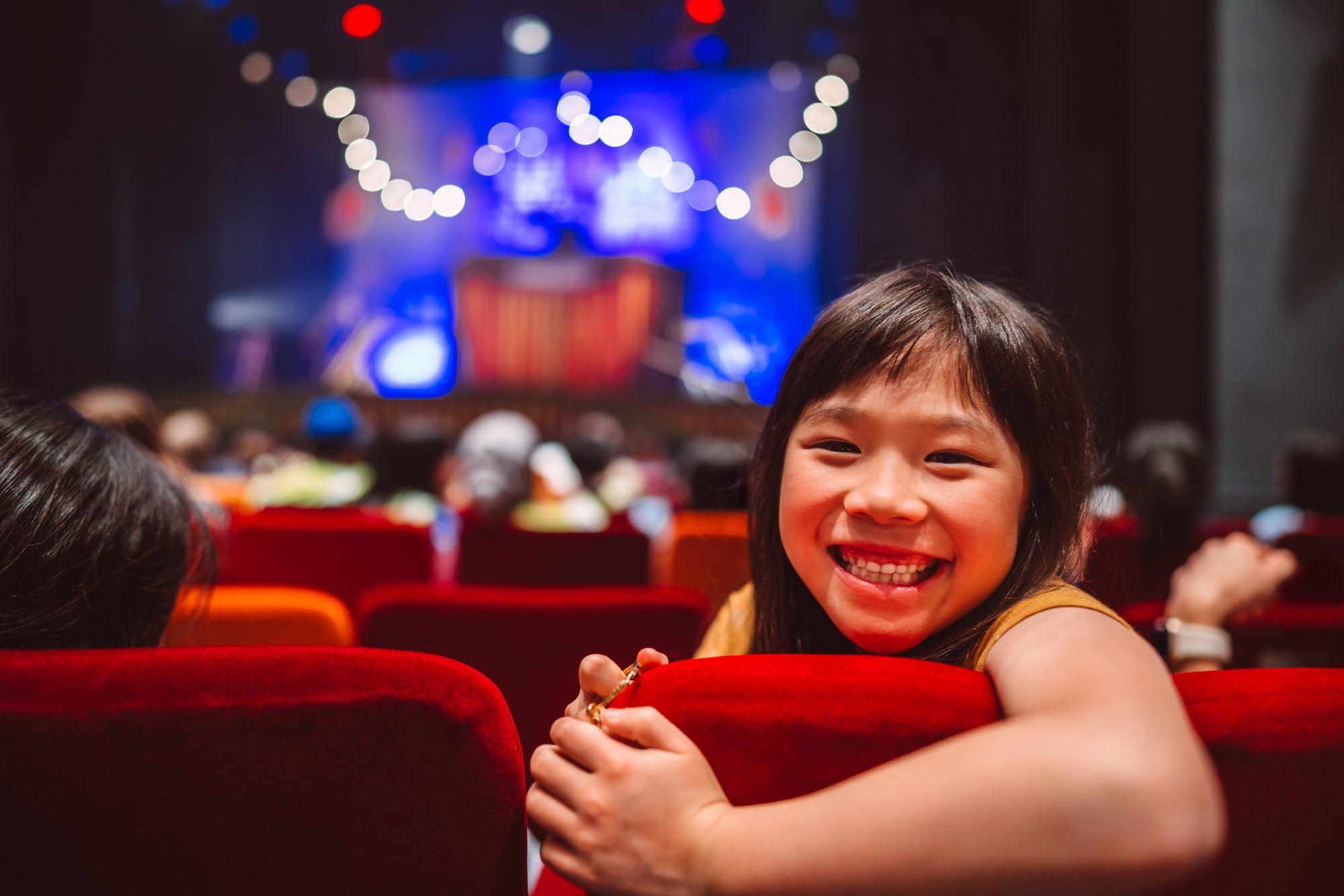 Excited young girl enjoying a family day at the theatre