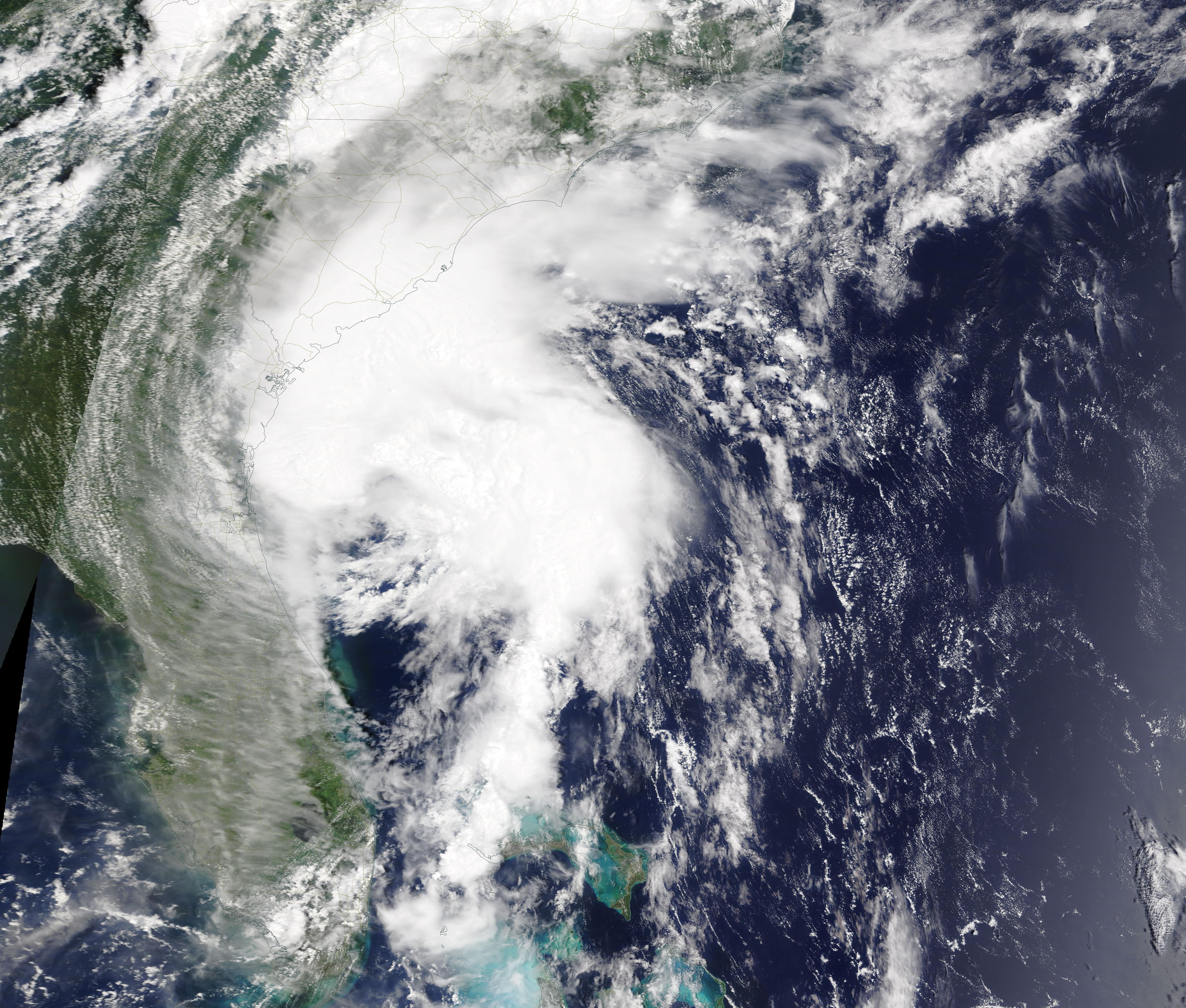 Satellite image of a hurricane with spiral cloud bands approaching the southeastern U.S. coast.