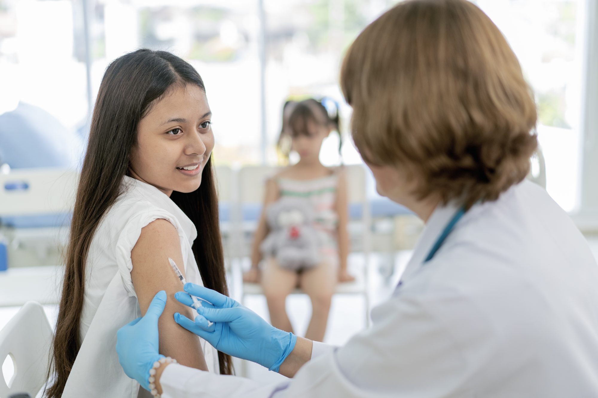 Nurse gives students a vaccination in school during coronavirus pandemic